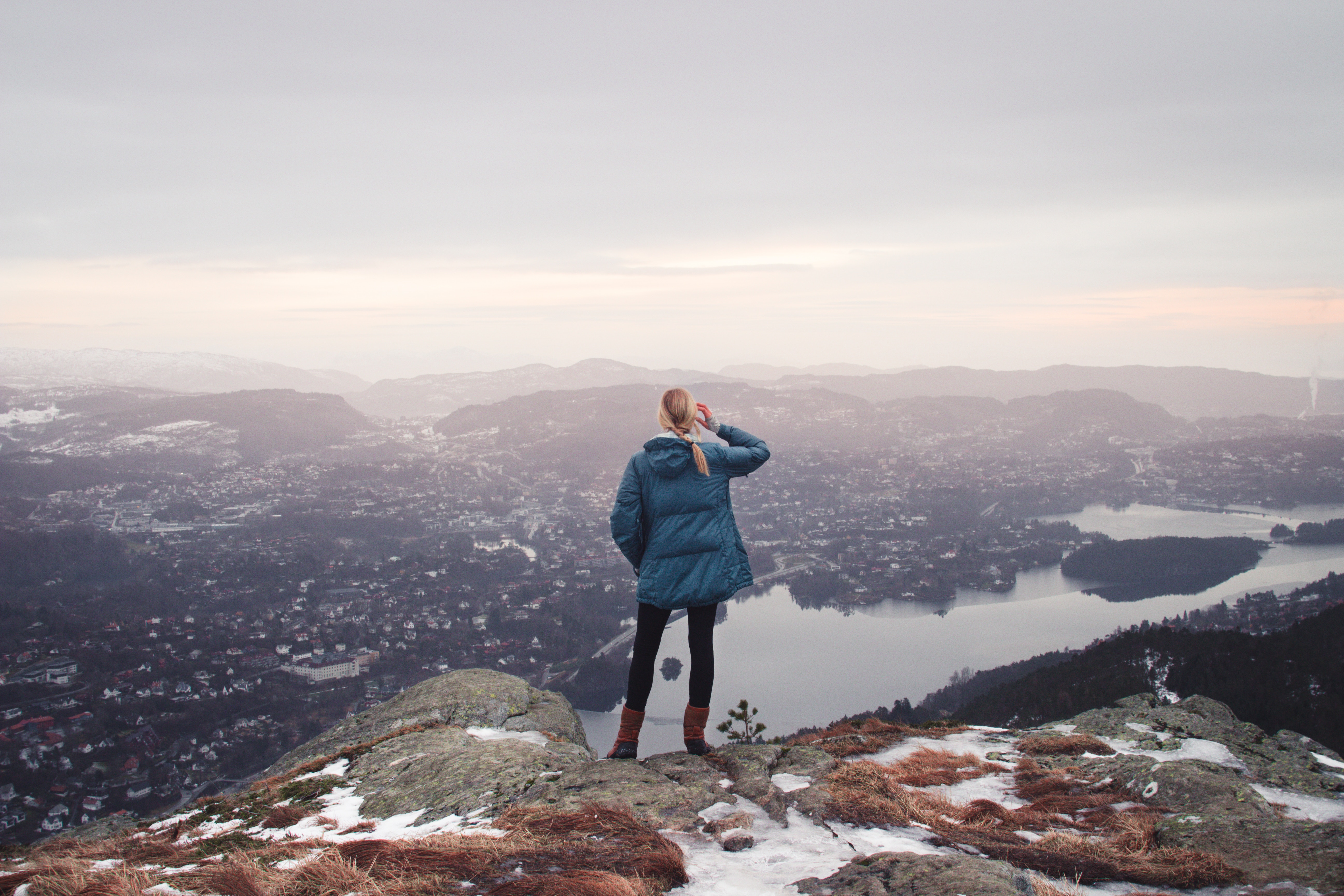 Woman on mountain top overlooking city and lake HD Wallpaper