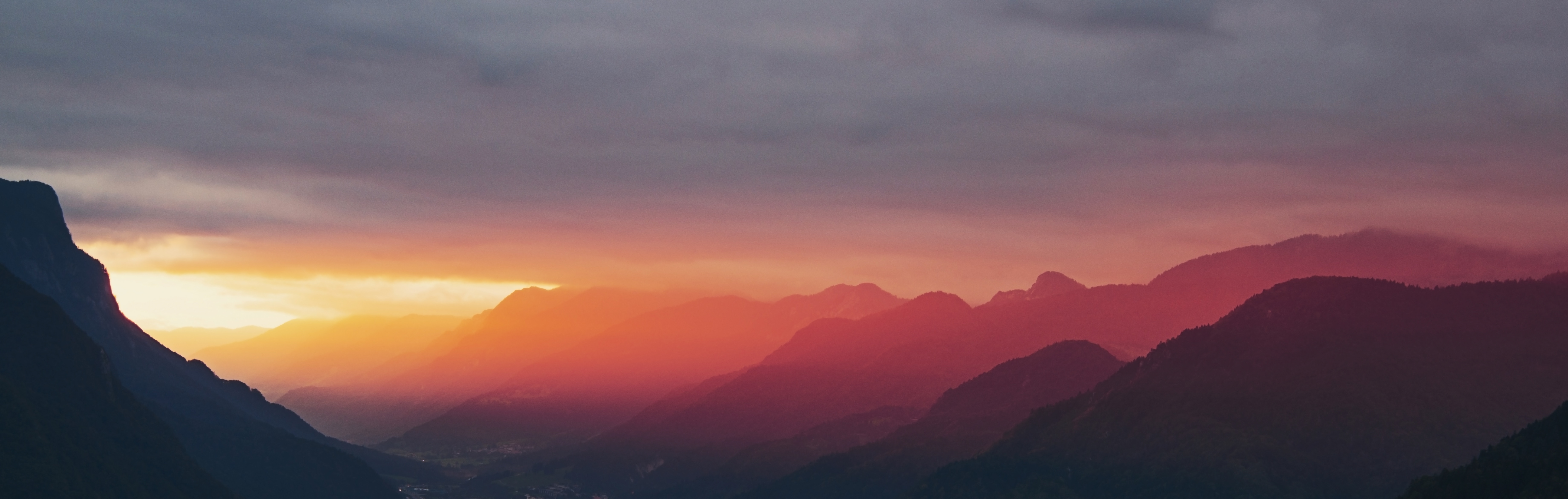 Mountain range silhouette at sunset with colorful sky HD Wallpaper