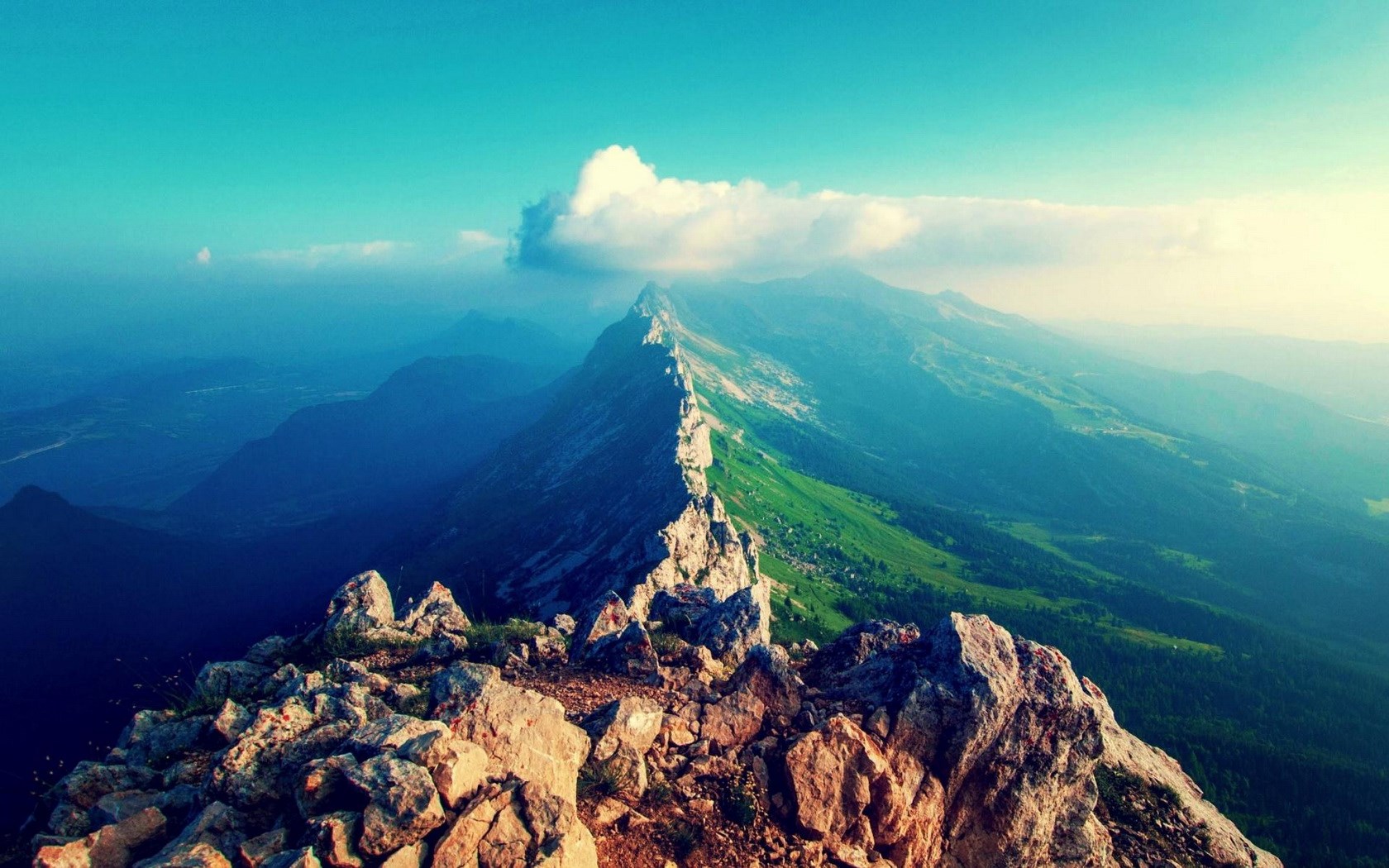 Mountain ridge with green slopes and rocky foreground HD Wallpaper