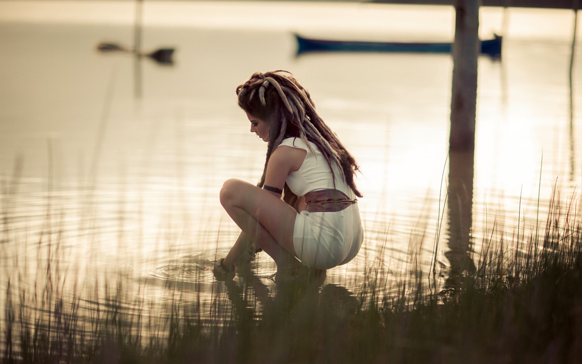 Peaceful Woman Sitting by Calm Lake at Sunset HD Wallpaper