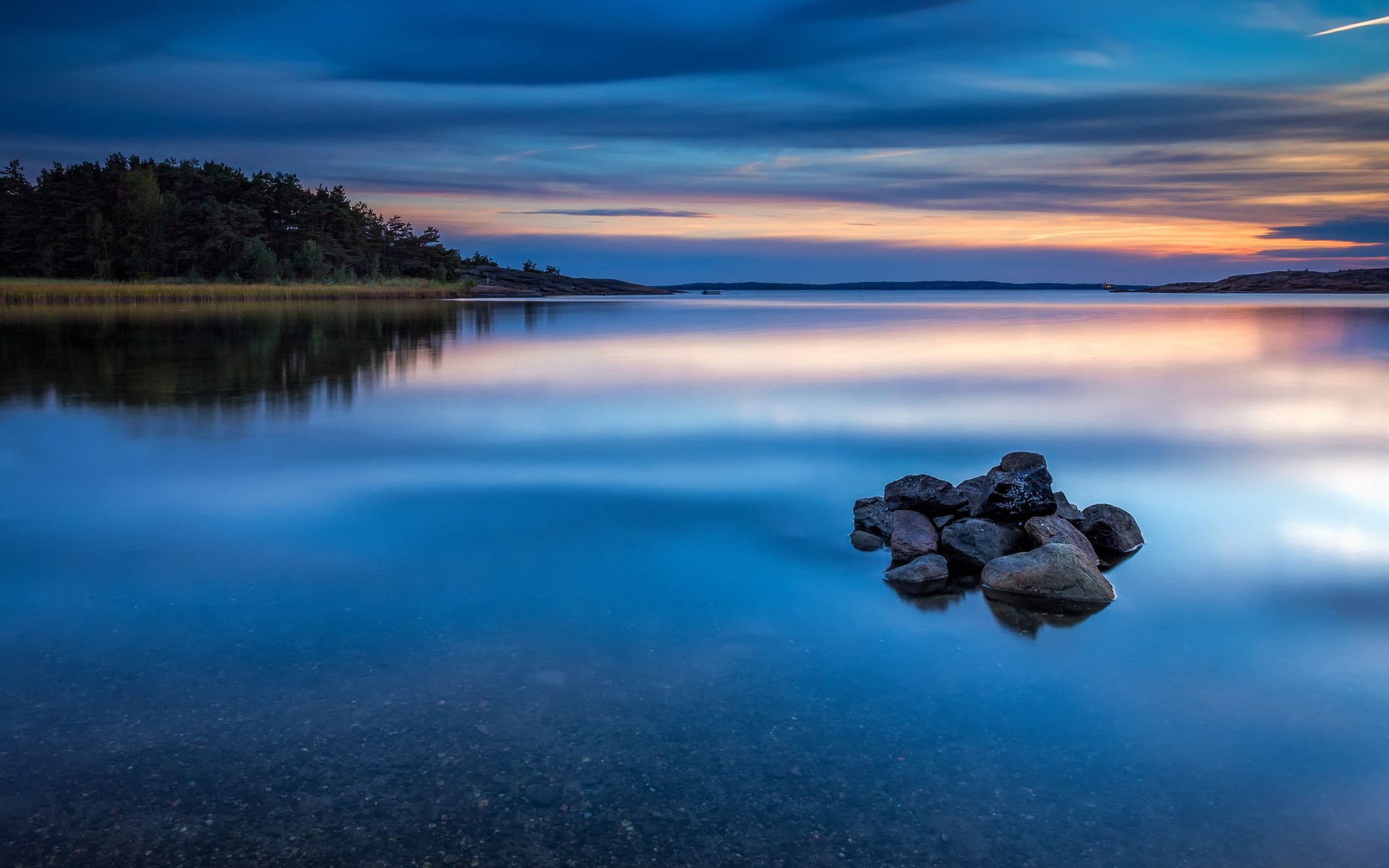 Calm lake at sunset with rocks HD Wallpaper