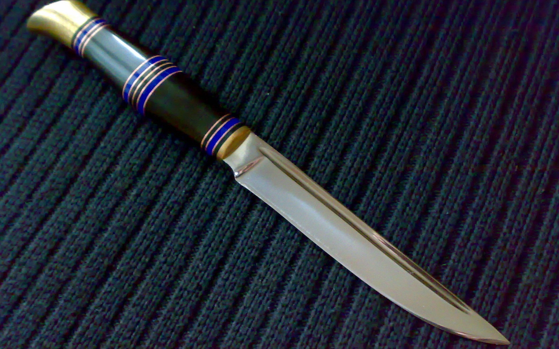 Knife with black handle and brass accents HD Wallpaper