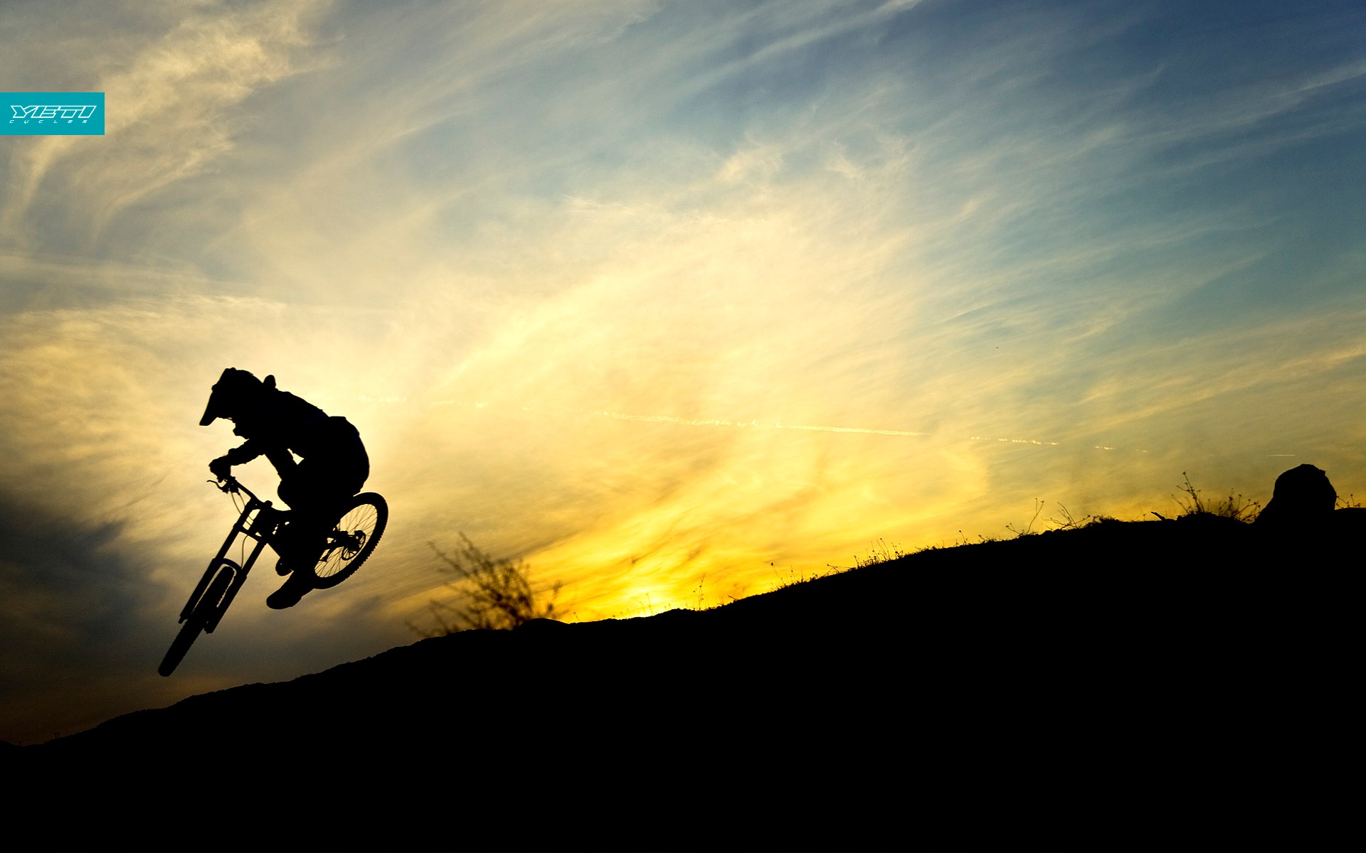 Silhouette of a mountain biker jumping against a sunset sky HD Wallpaper