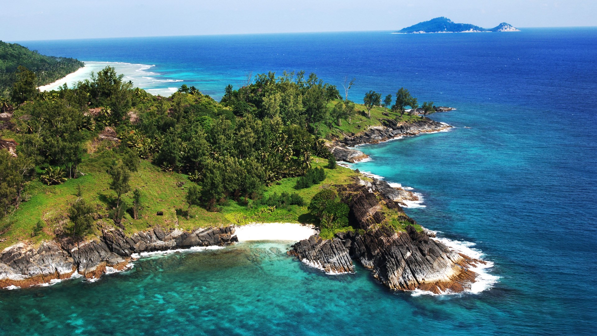 Island coastline with turquoise water and distant islands HD Wallpaper