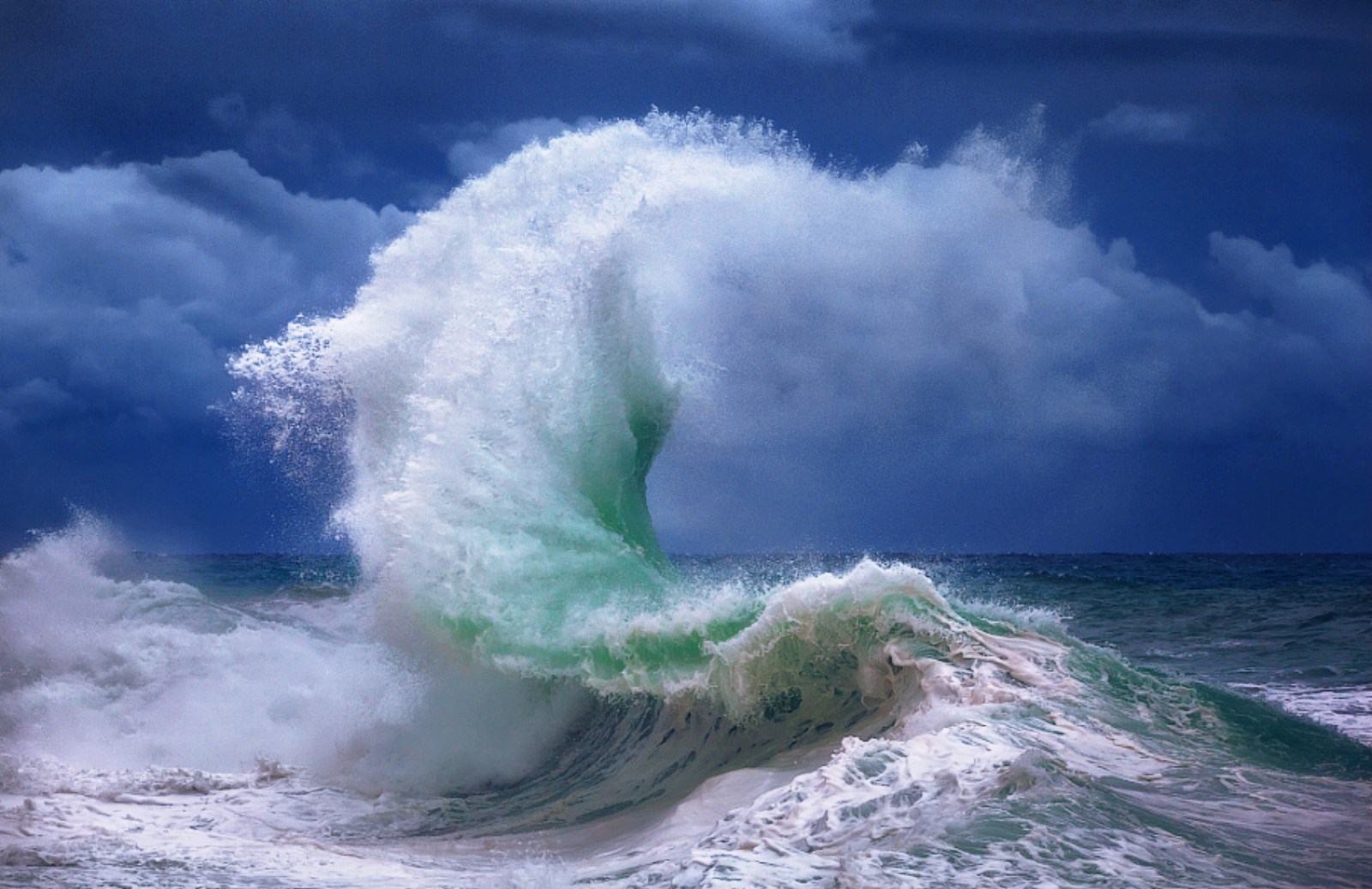 Crashing Ocean Wave Under Dark Clouds HD Wallpaper