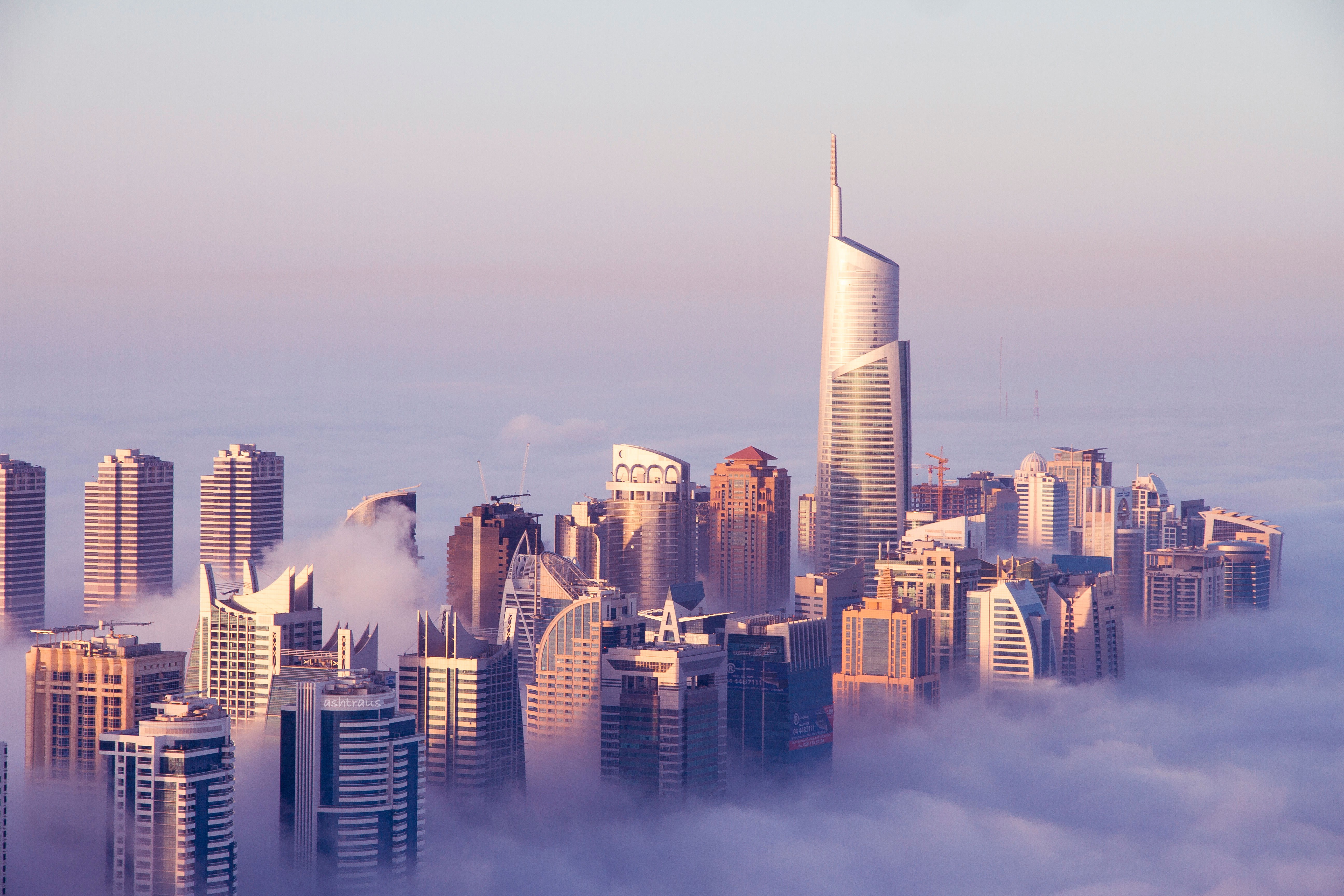 Dubai skyscrapers emerging from clouds at sunrise HD Wallpaper