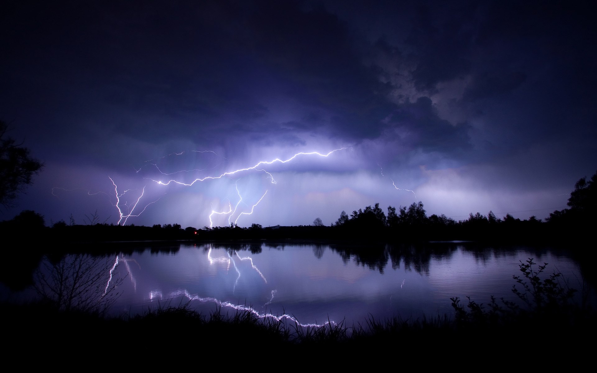 Lightning strikes over a lake at night HD Wallpaper