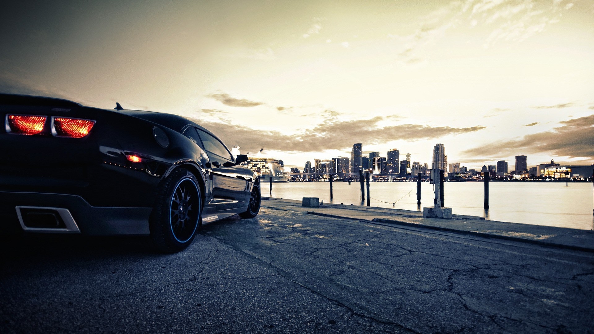 Black Sports Car on Waterfront with City Skyline HD Wallpaper