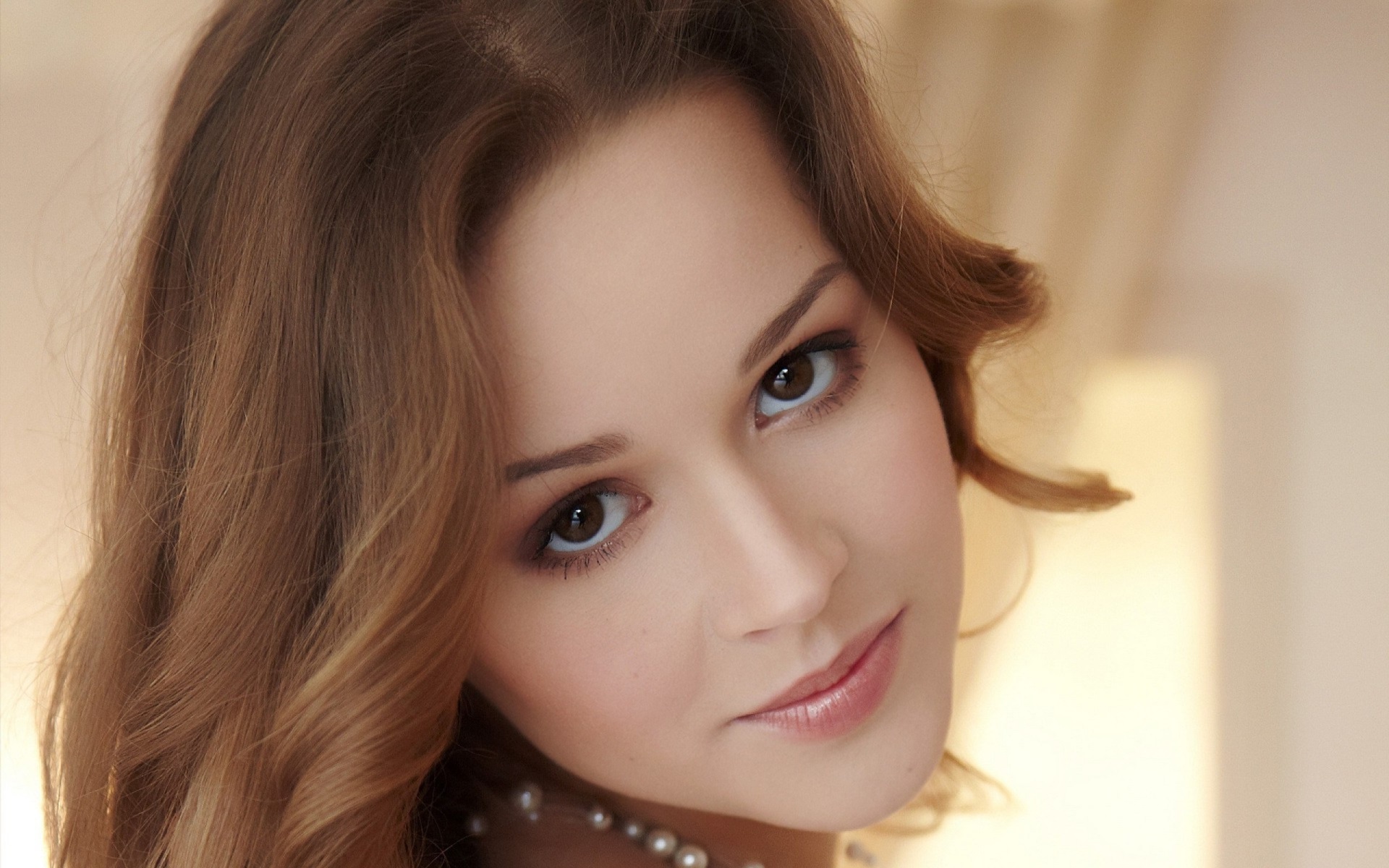 Close-up of a Smiling Woman with Pearl Necklace HD Wallpaper