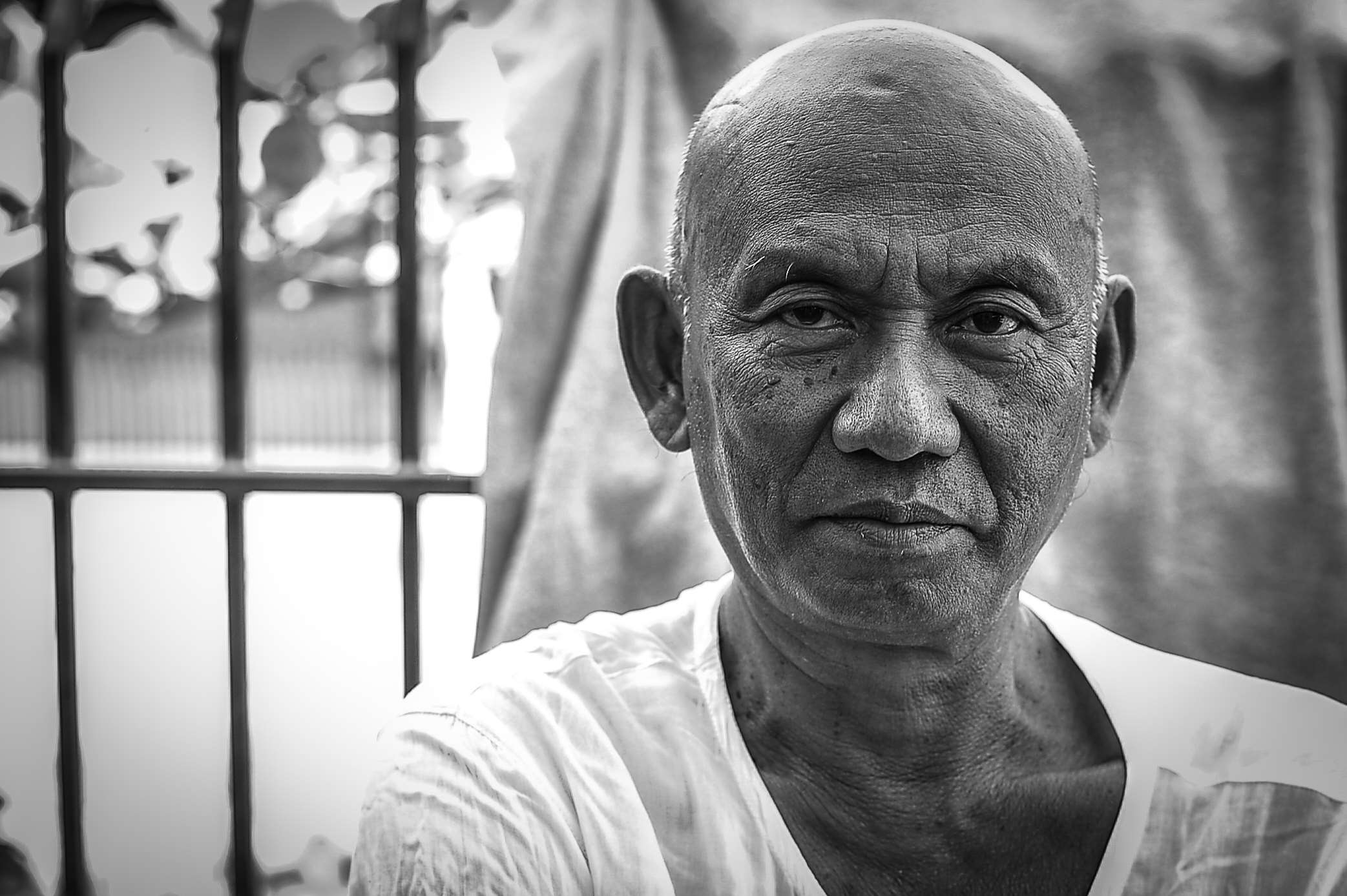 Elderly man with weathered face in black and white portrait HD Wallpaper