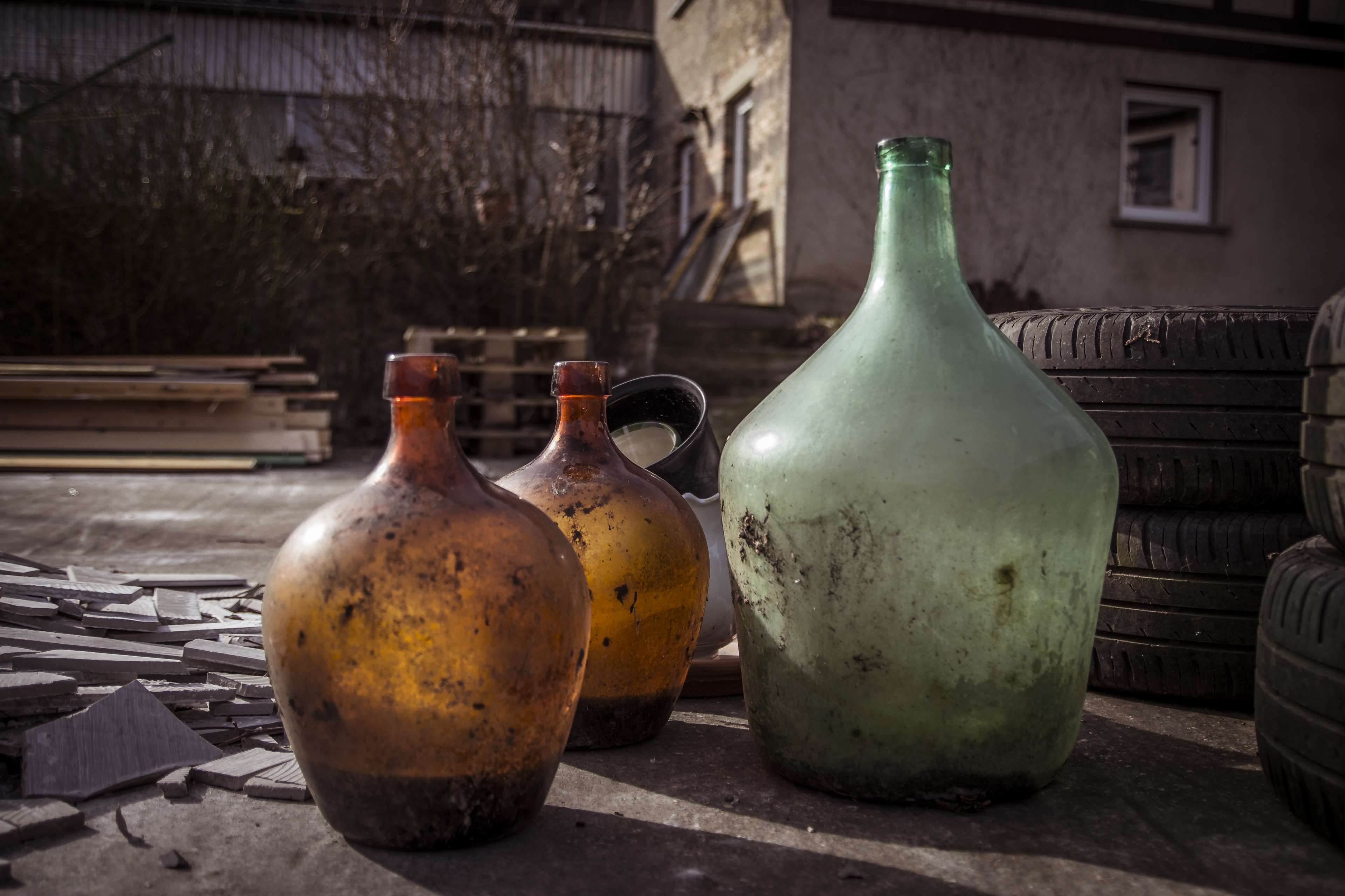 Vintage glass bottles and tires outside a building HD Wallpaper