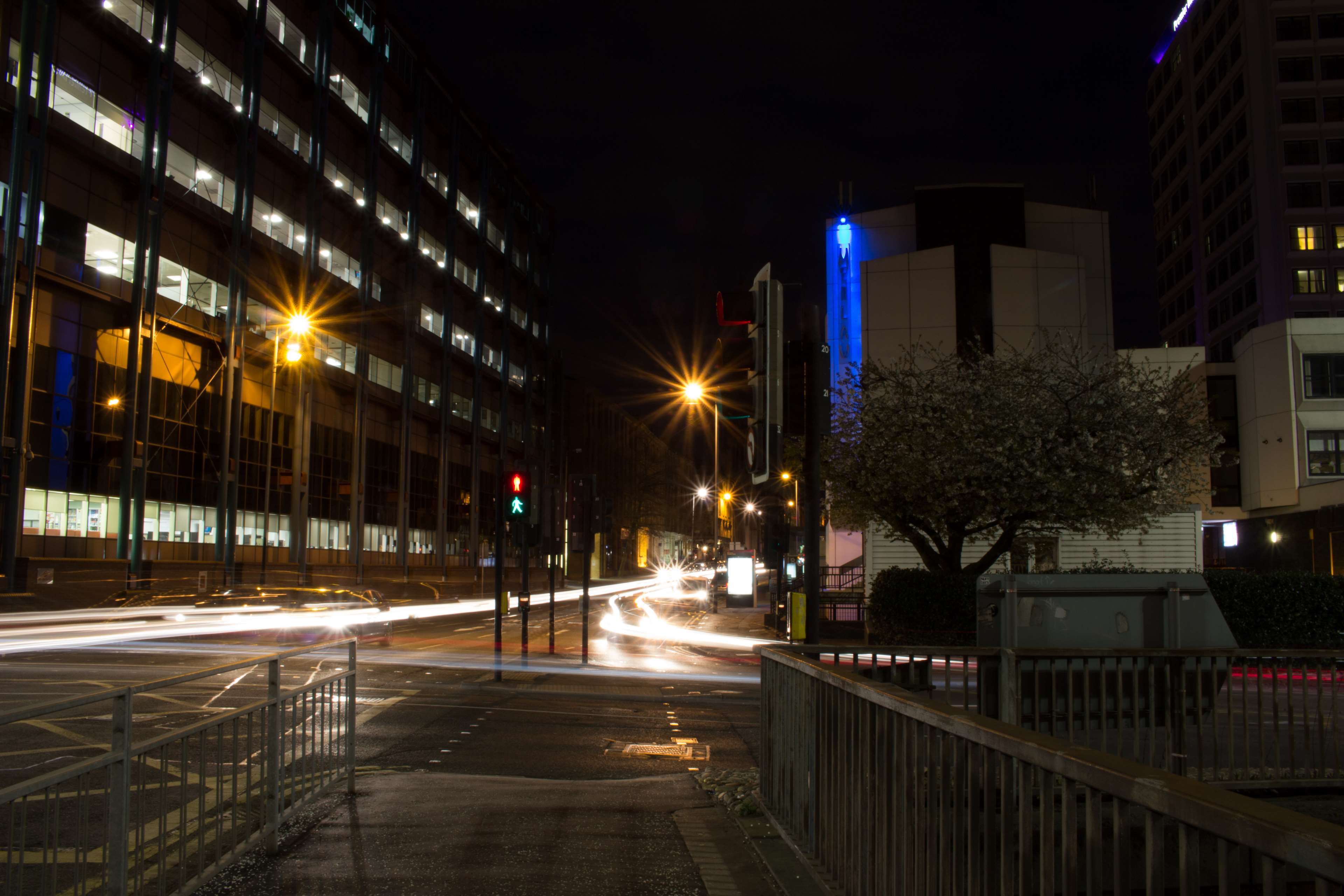 City street at night with light trails from cars HD Wallpaper