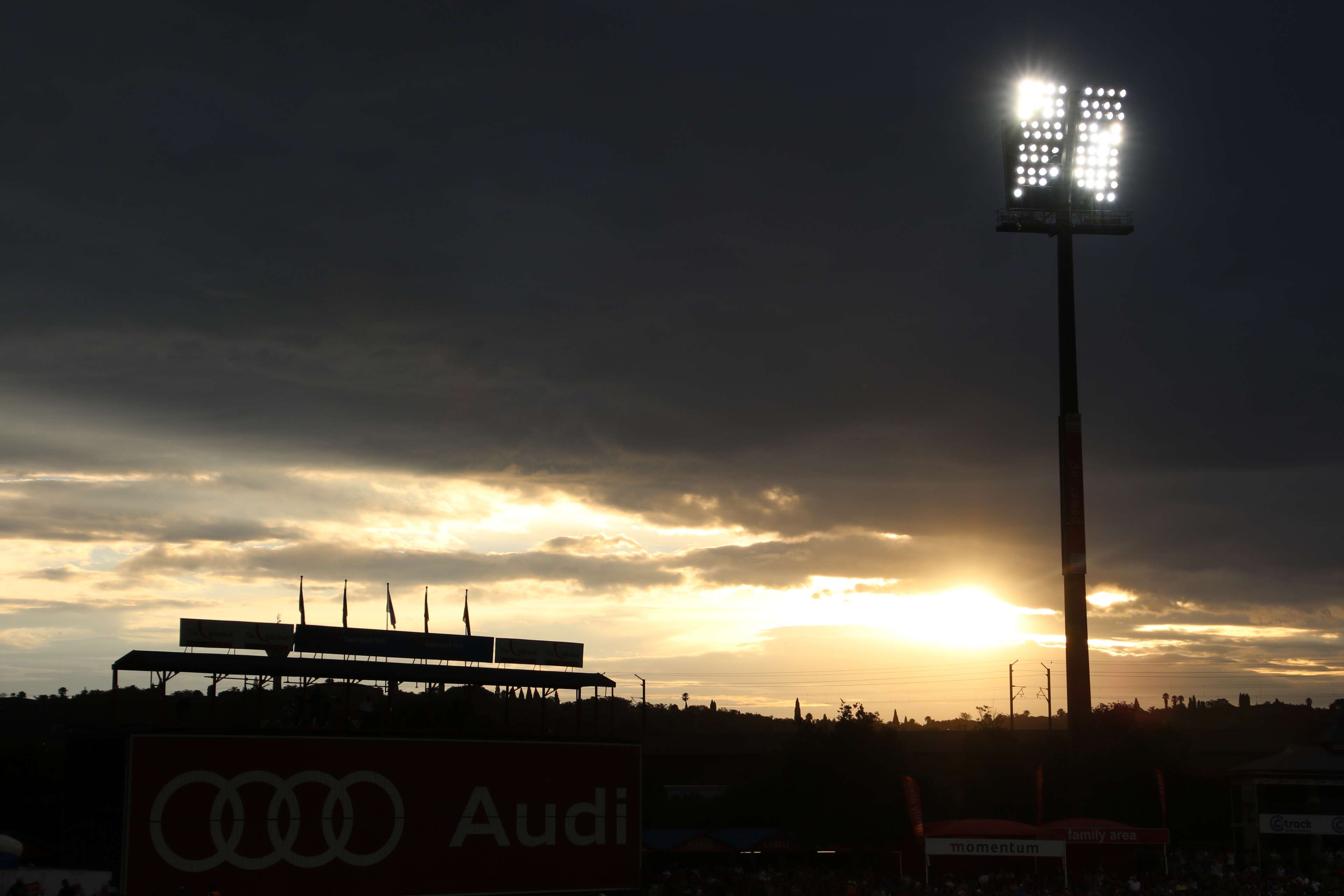 Stadium floodlights at sunset with Audi billboard HD Wallpaper