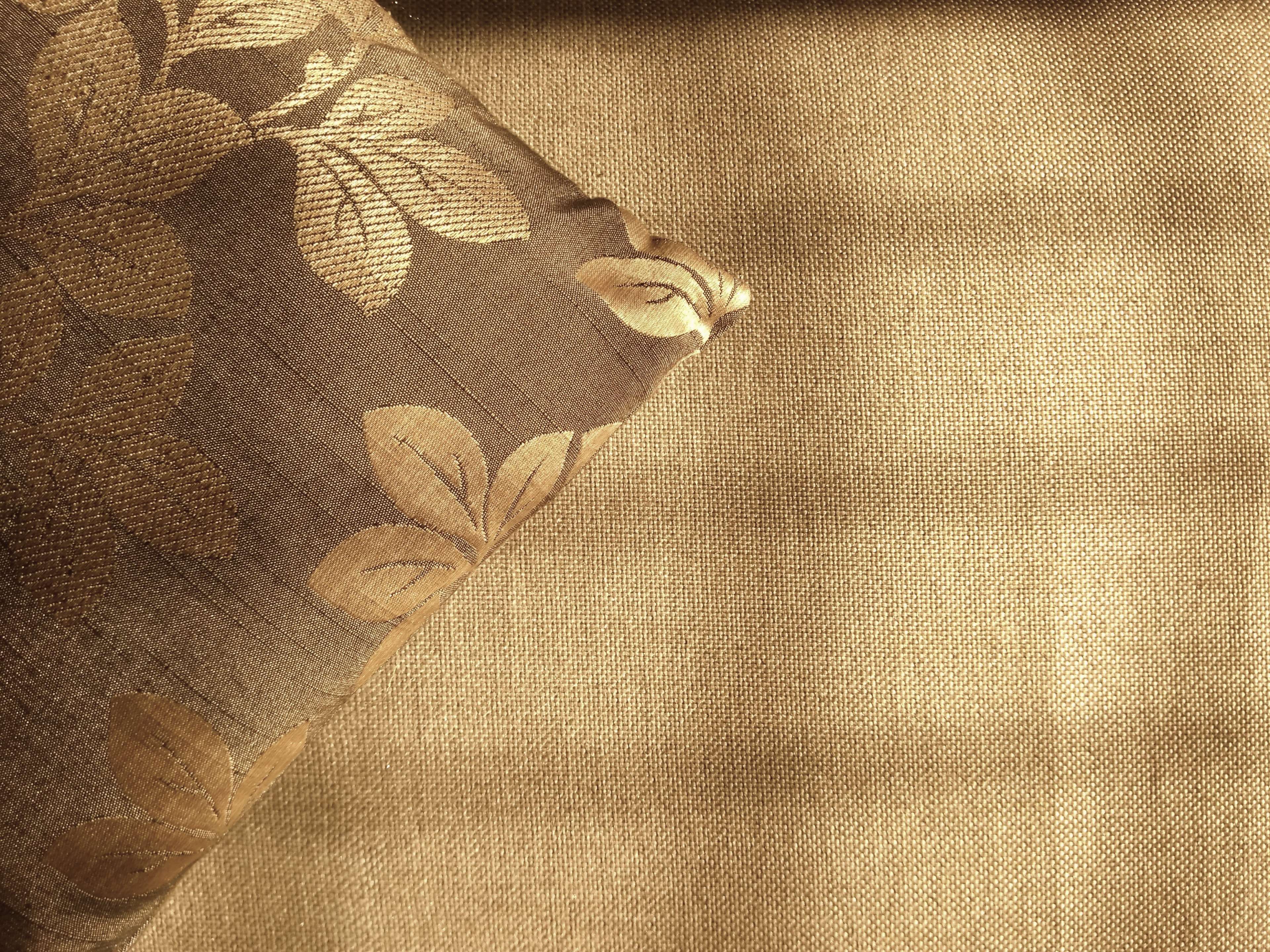 Brown fabric cushion with floral design and textured background HD Wallpaper