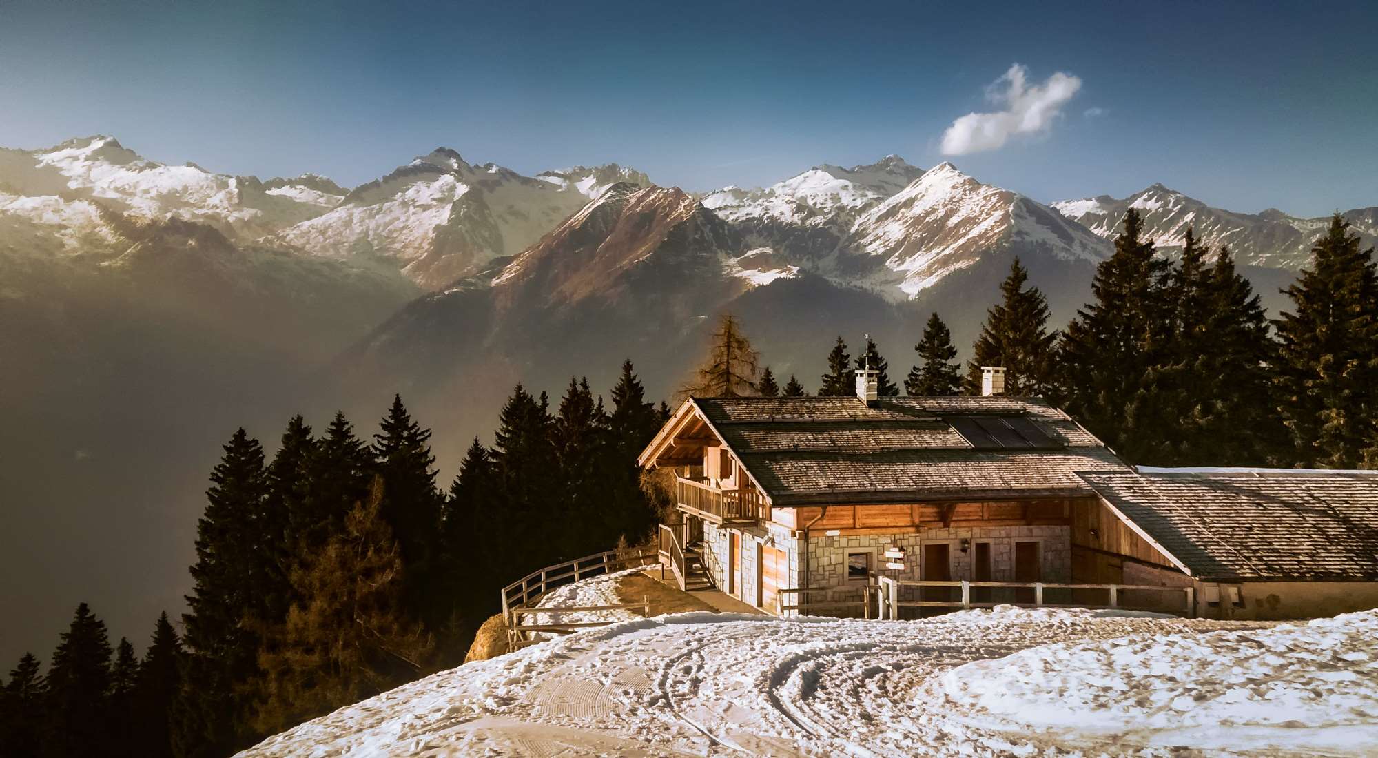 Wooden house in snowy mountains with pine trees HD Wallpaper