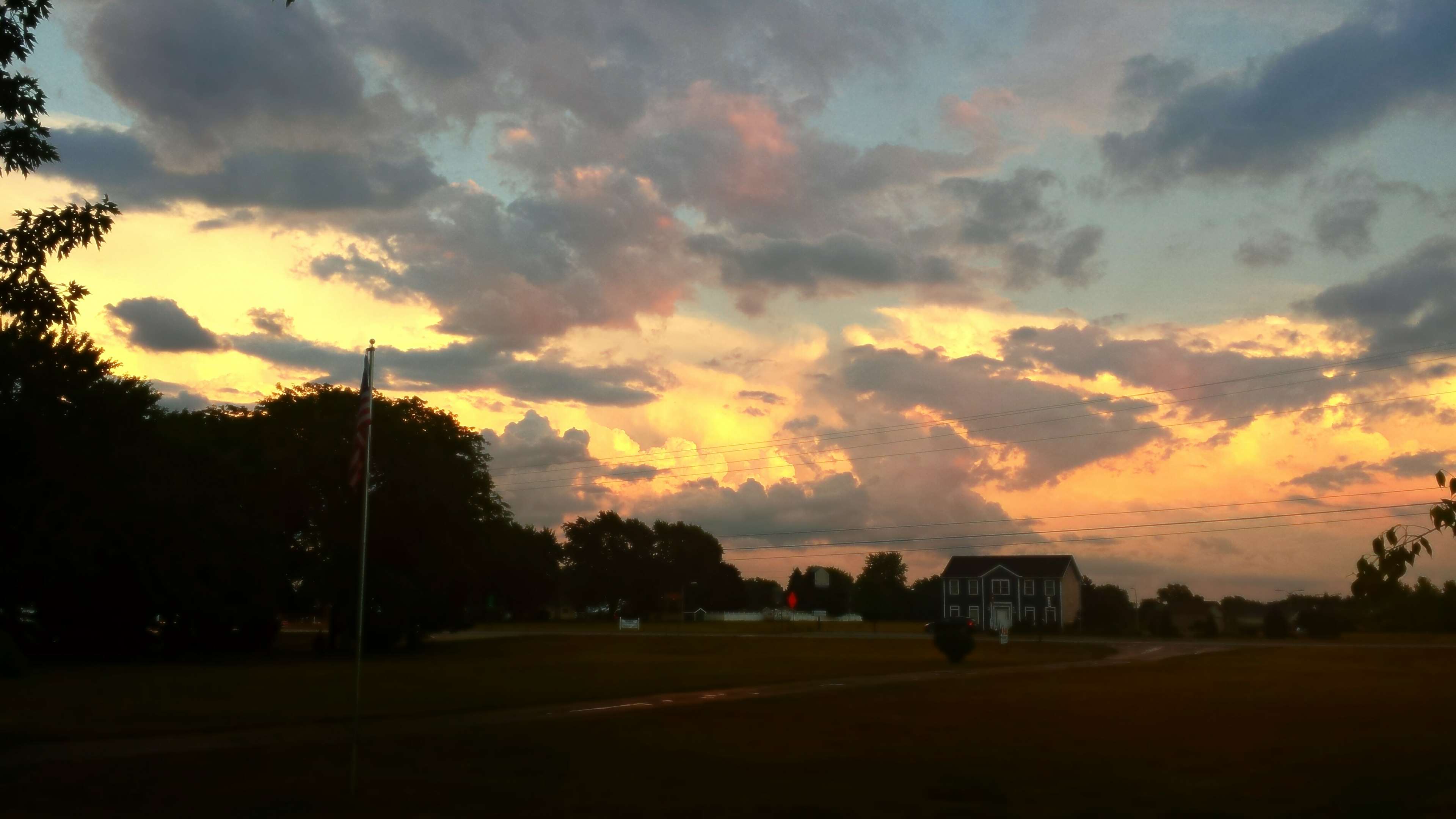 Sunset clouds over a rural landscape with a house HD Wallpaper