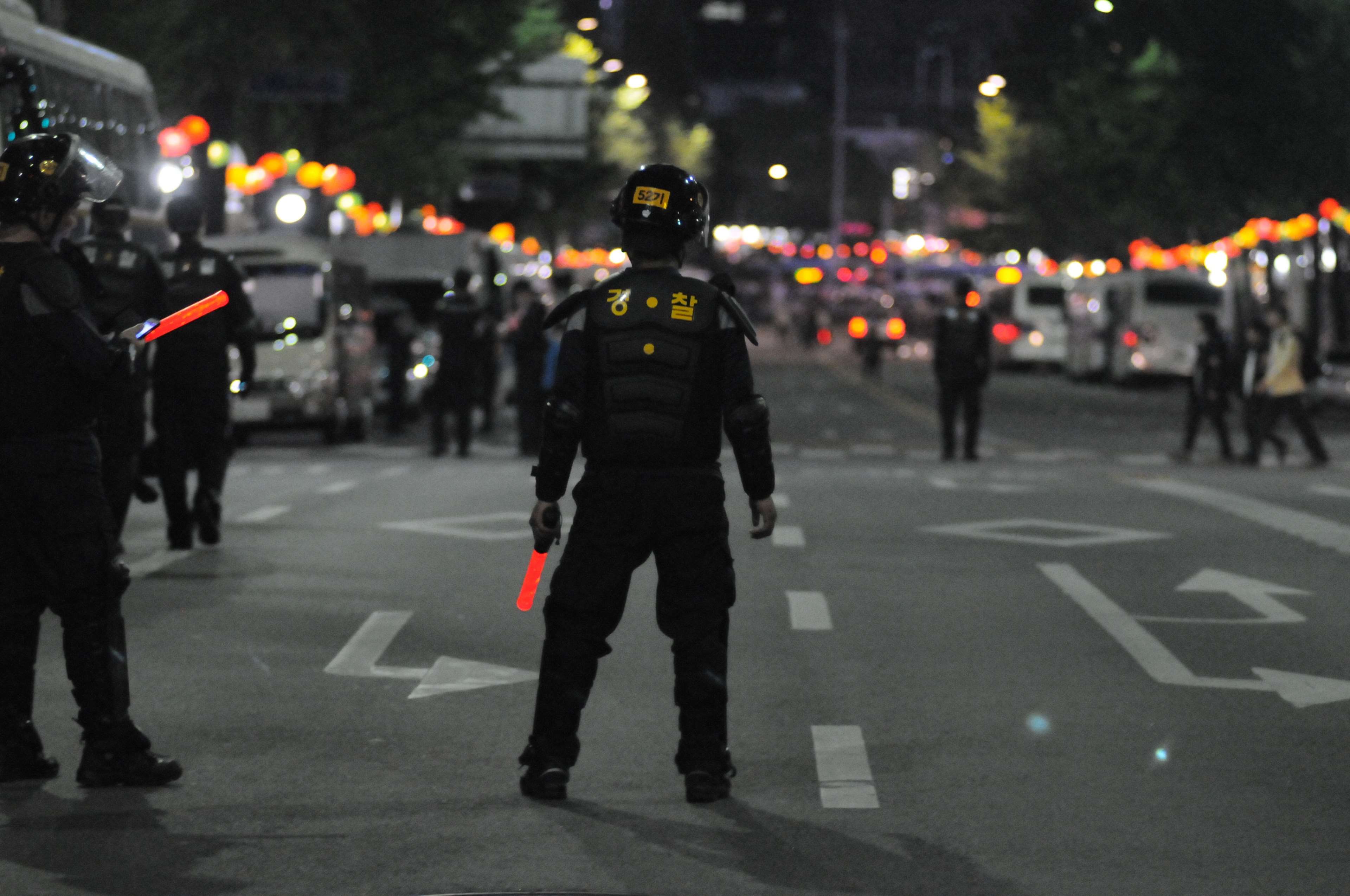 Police officers with riot gear and batons on a city street at night HD Wallpaper