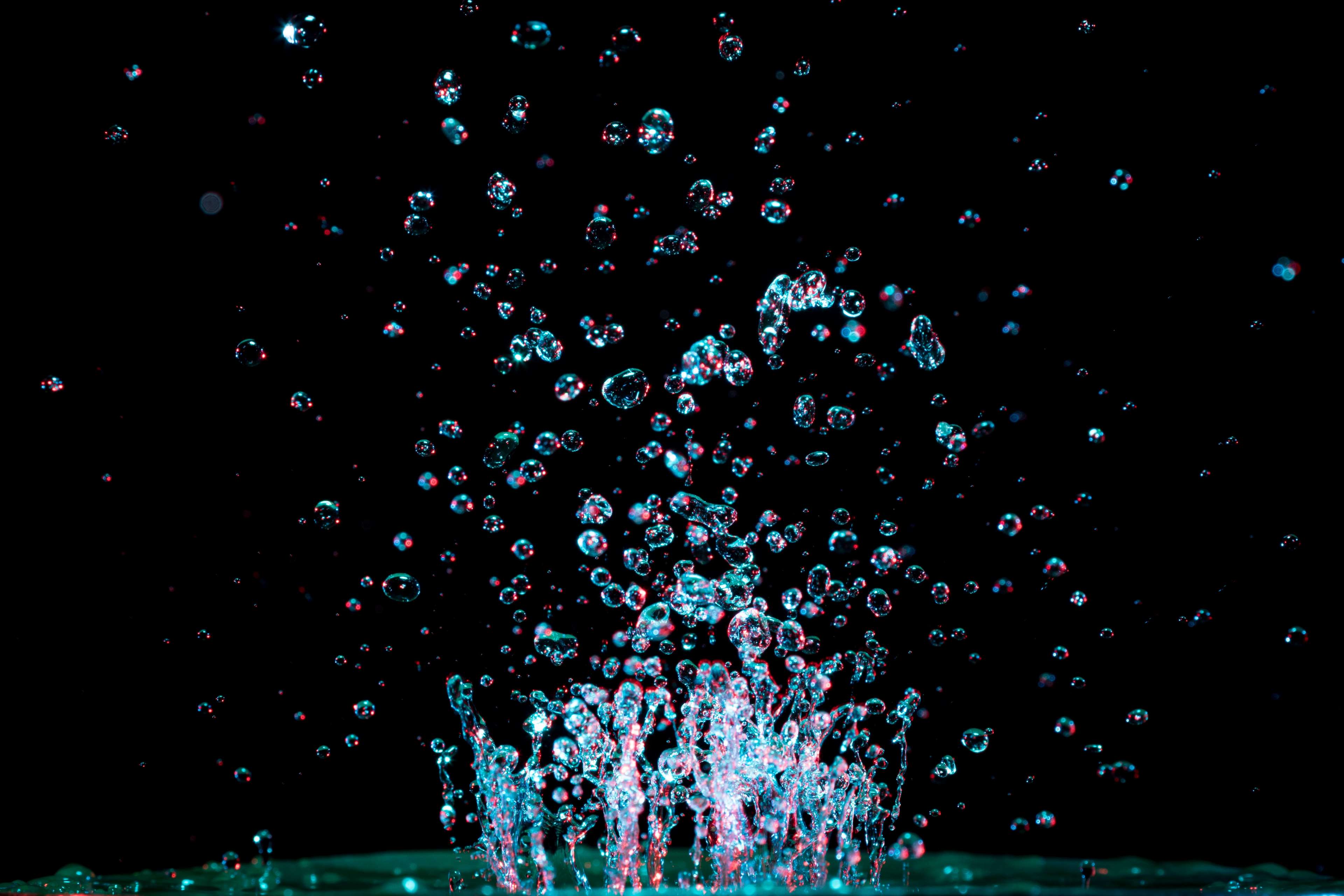 Water droplets splashing in dark background HD Wallpaper
