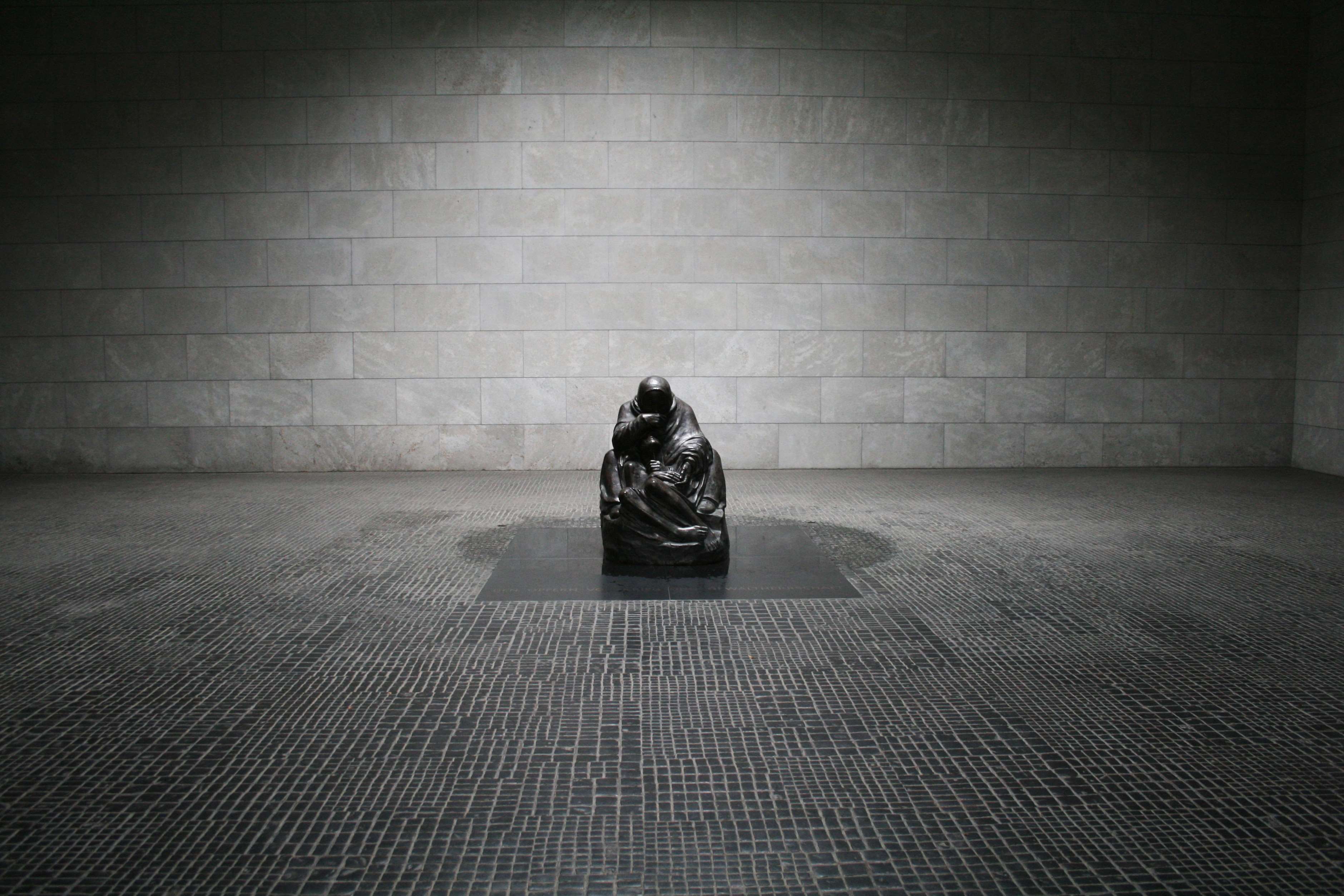 Sculpture of a seated figure in a museum hall HD Wallpaper