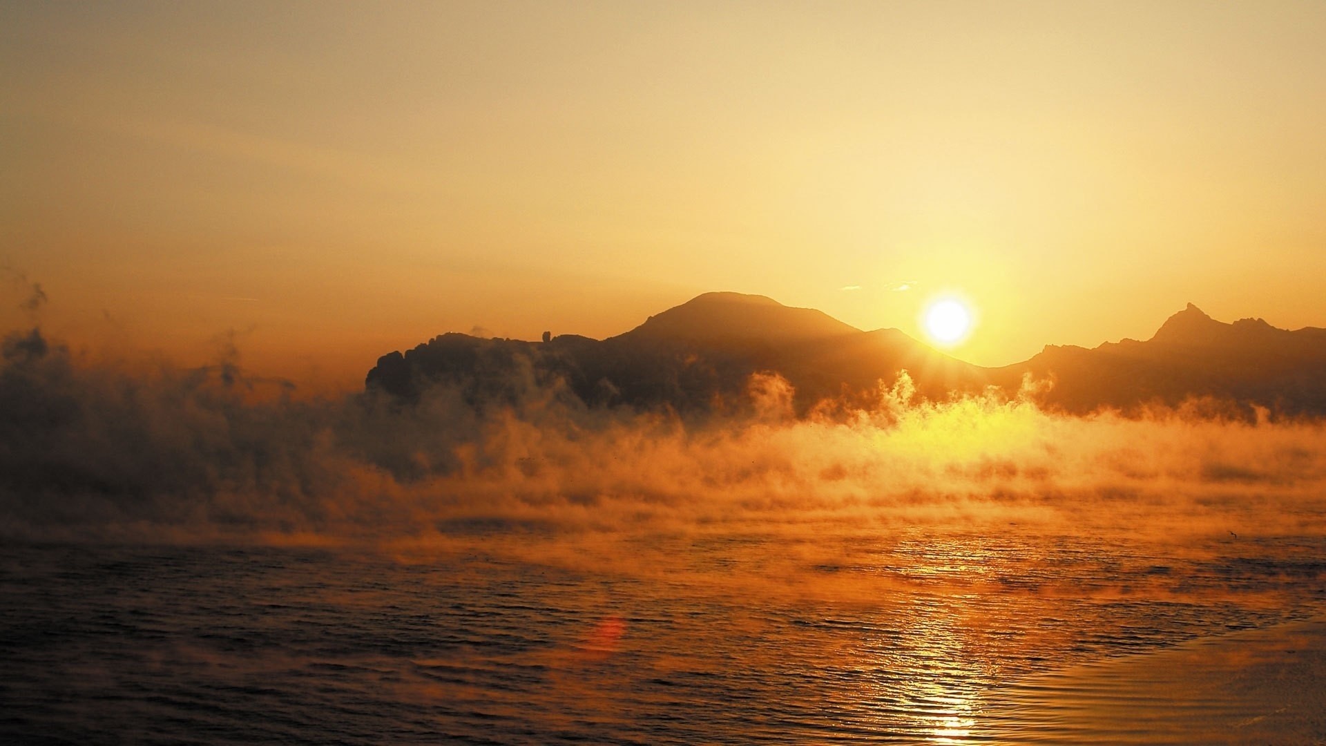 Sunrise over misty mountains and water HD Wallpaper