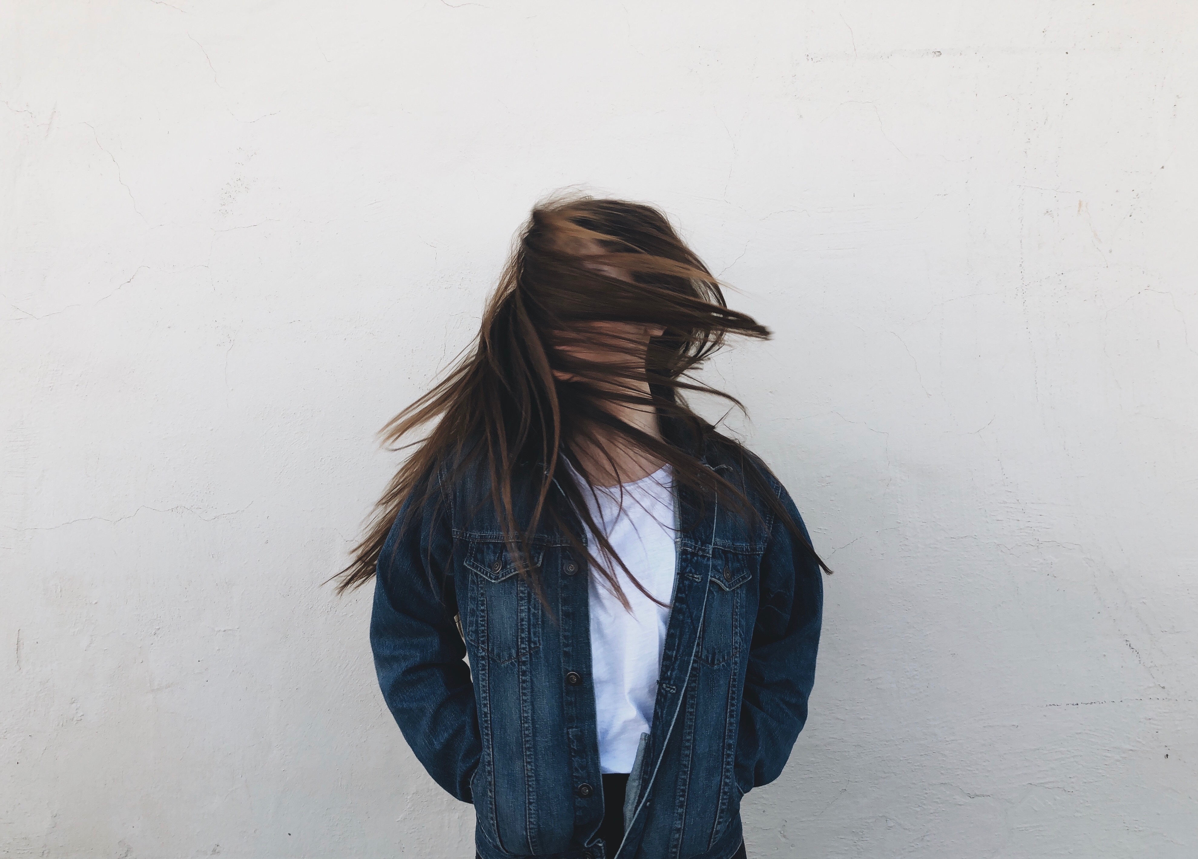 Woman with hair in face wearing denim jacket HD Wallpaper