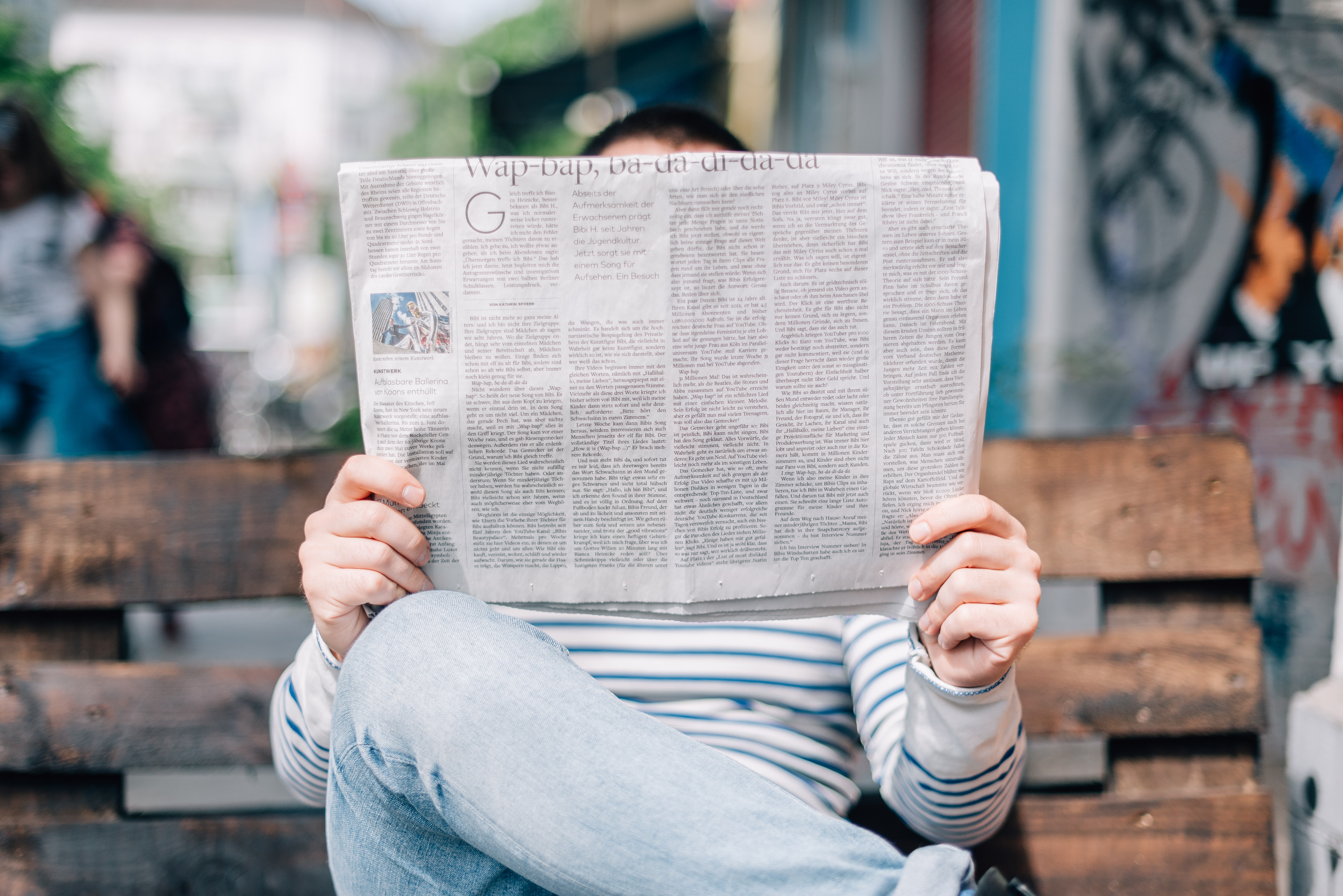 Person reading a newspaper outdoors HD Wallpaper