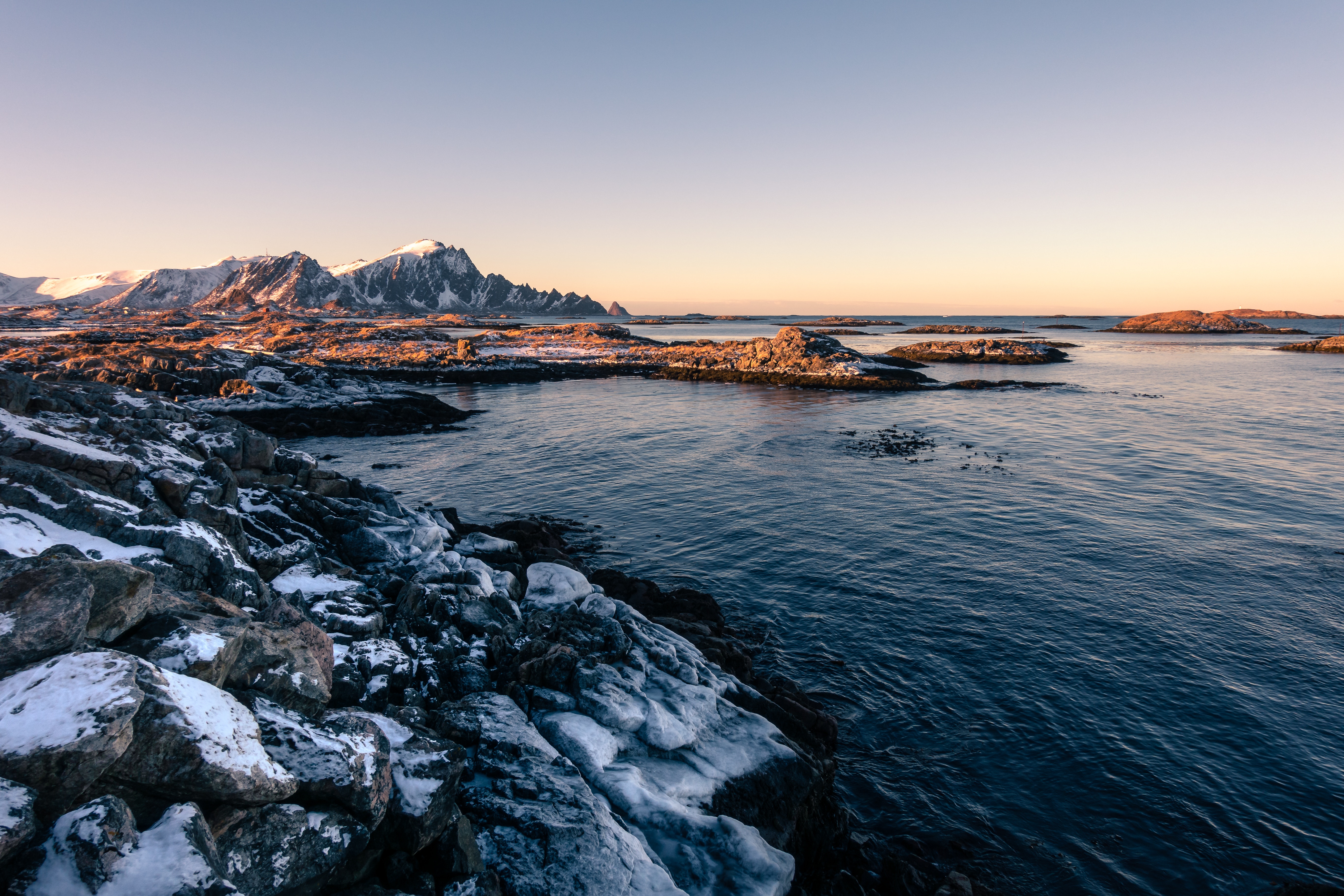 Snowy mountains and rocky coast at sunrise in Vesteralen, Norway HD Wallpaper