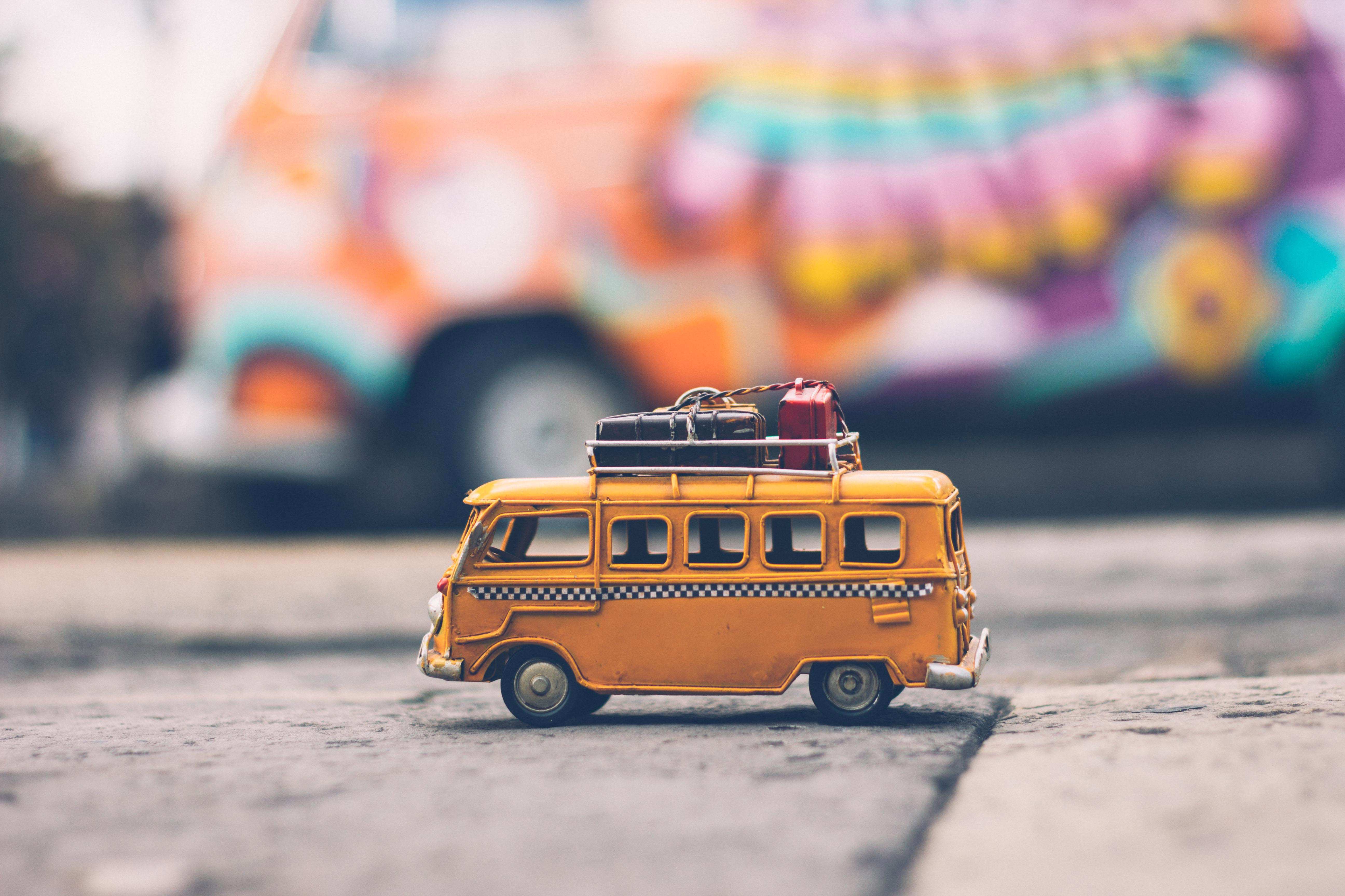 Yellow toy van with luggage on roof HD Wallpaper