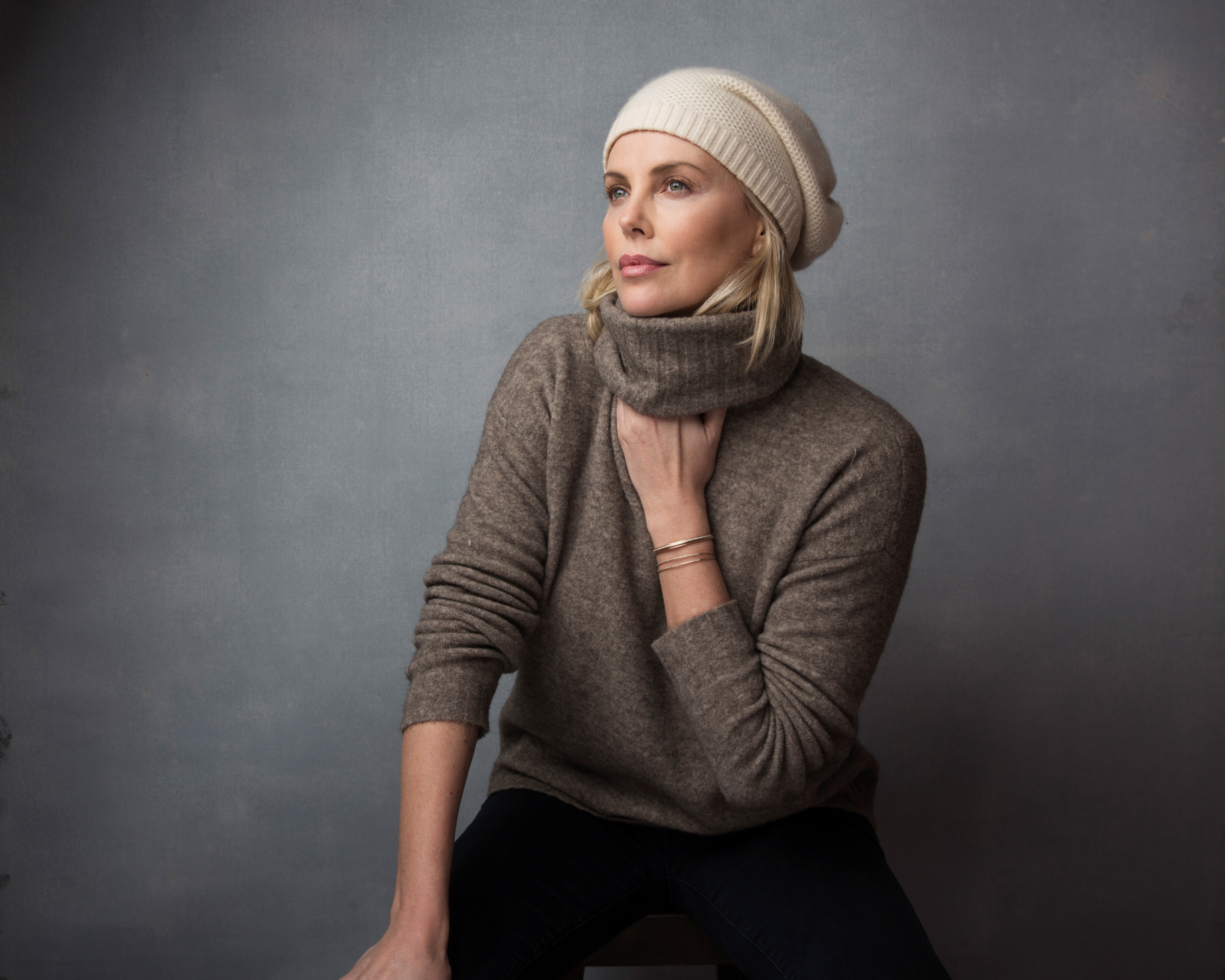 Charlize Theron wearing a beanie and sweater HD Wallpaper