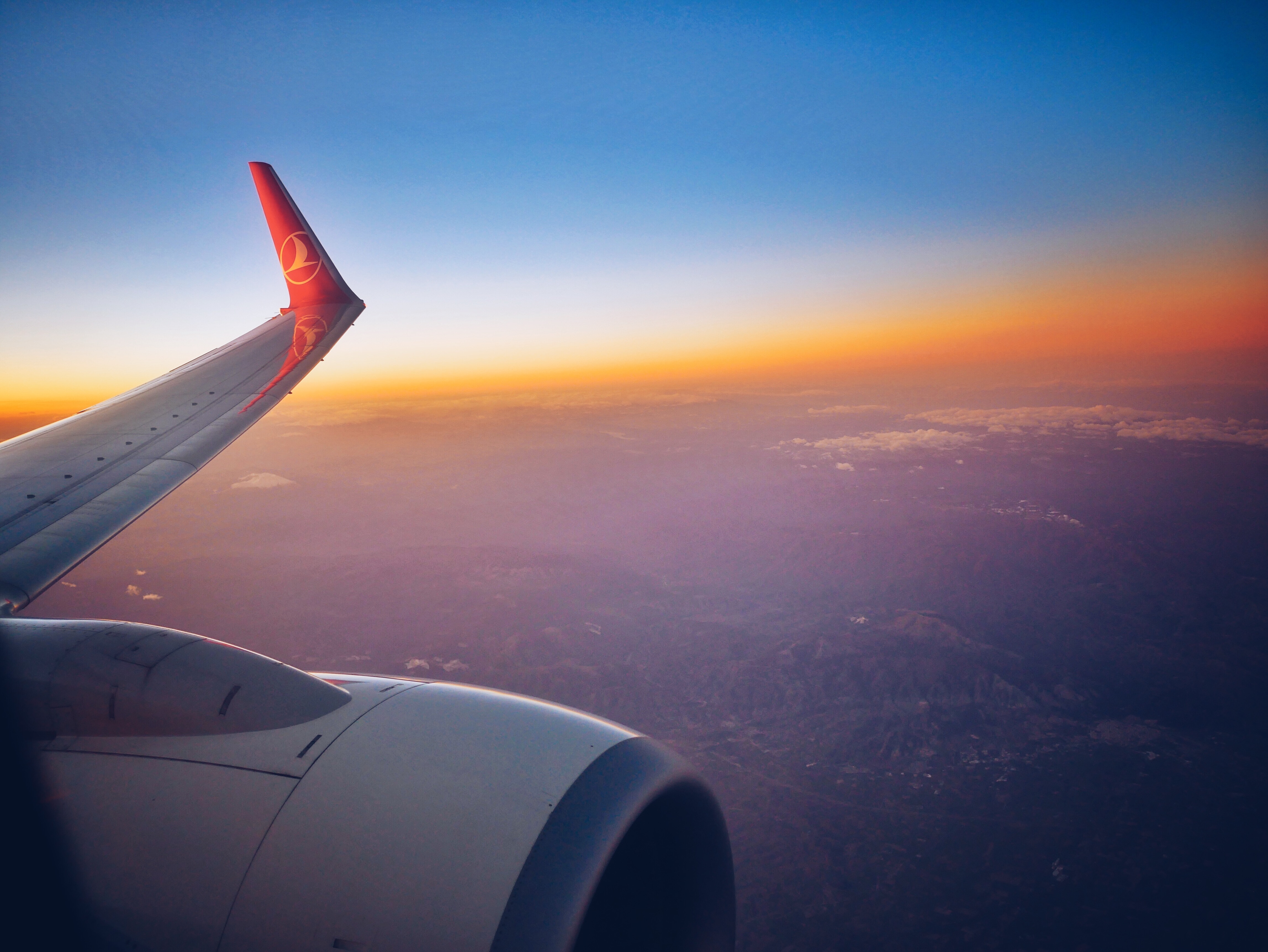 Turkish Airlines plane wing at sunset over landscape HD Wallpaper