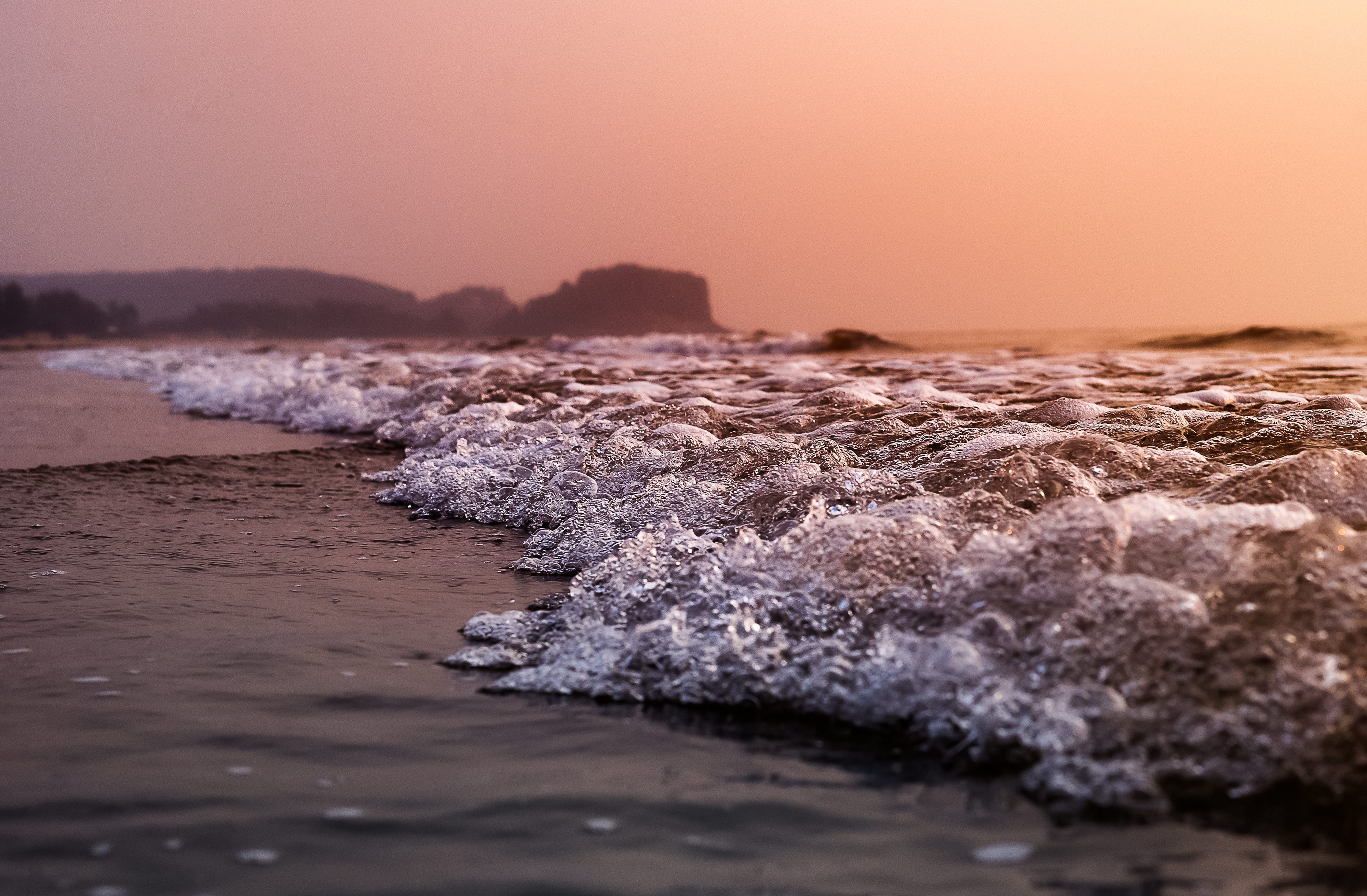 Waves crashing on the shore at sunset in Kashid, India HD Wallpaper