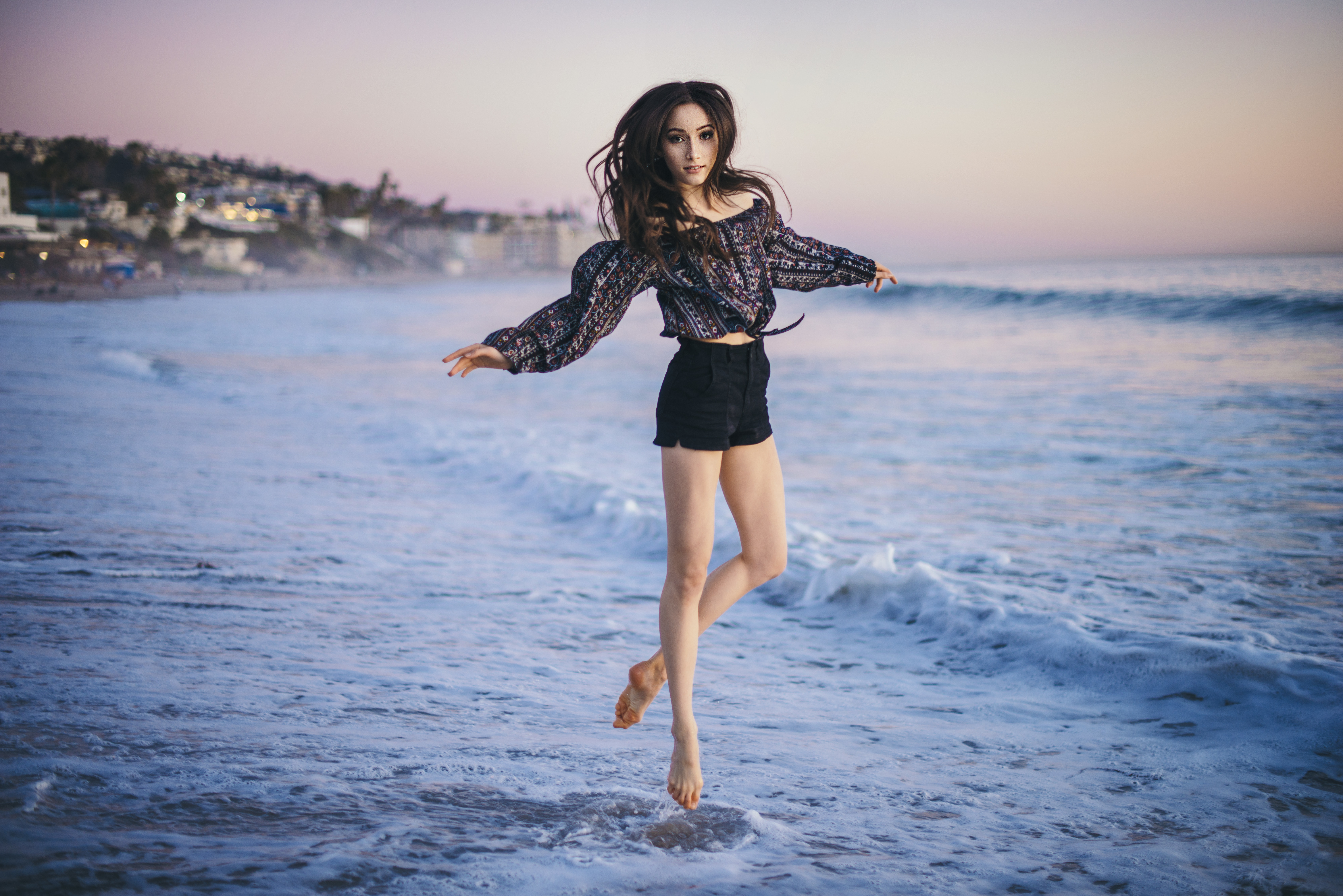 Girl jumping in the ocean at sunset HD Wallpaper