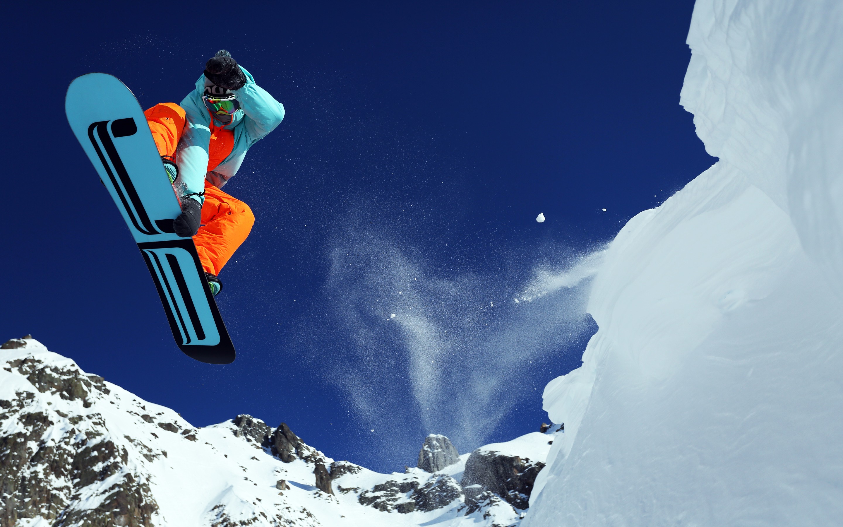 Snowboarder jumping off a snowy mountain cliff HD Wallpaper