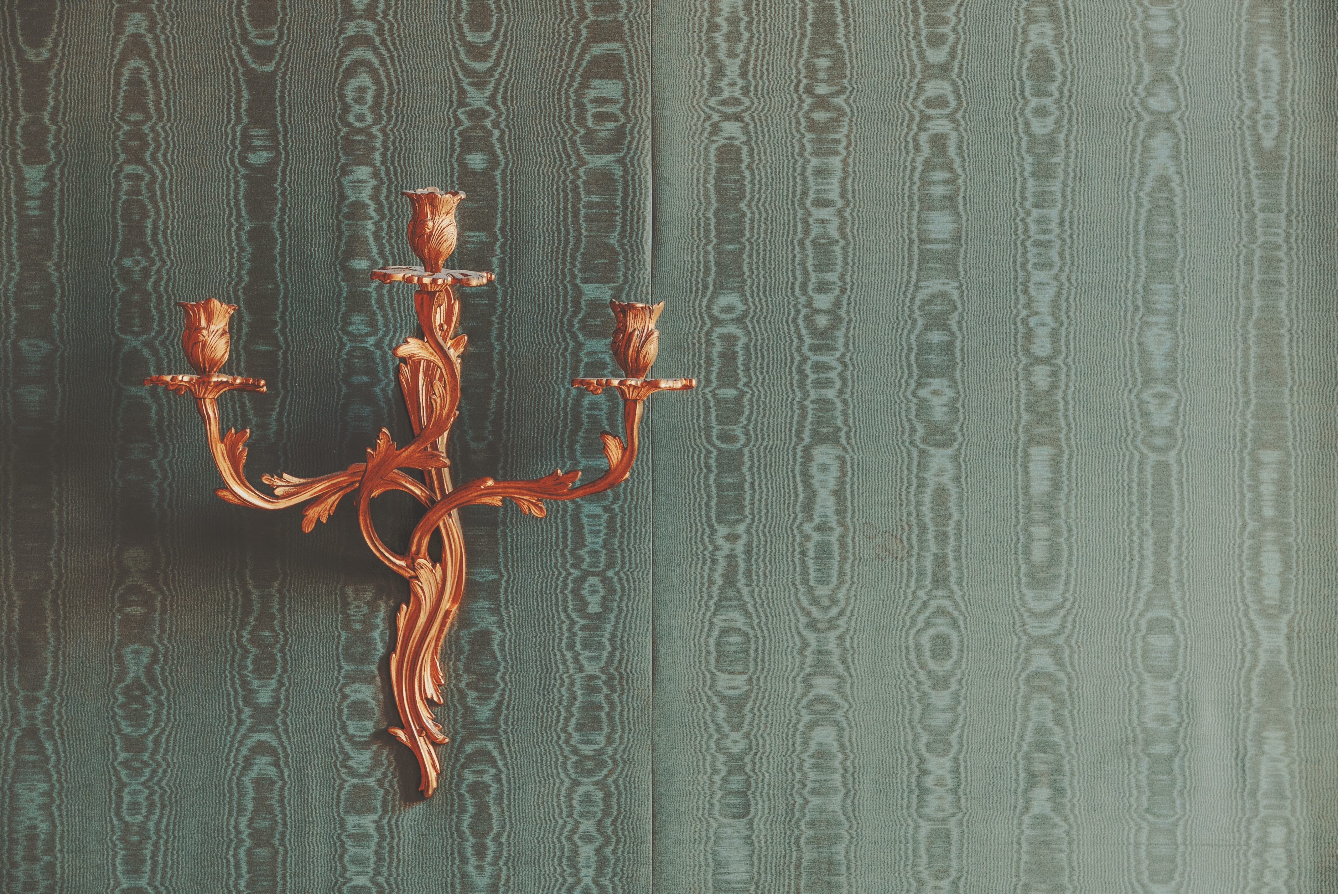 Gold candelabra on a patterned green wall HD Wallpaper