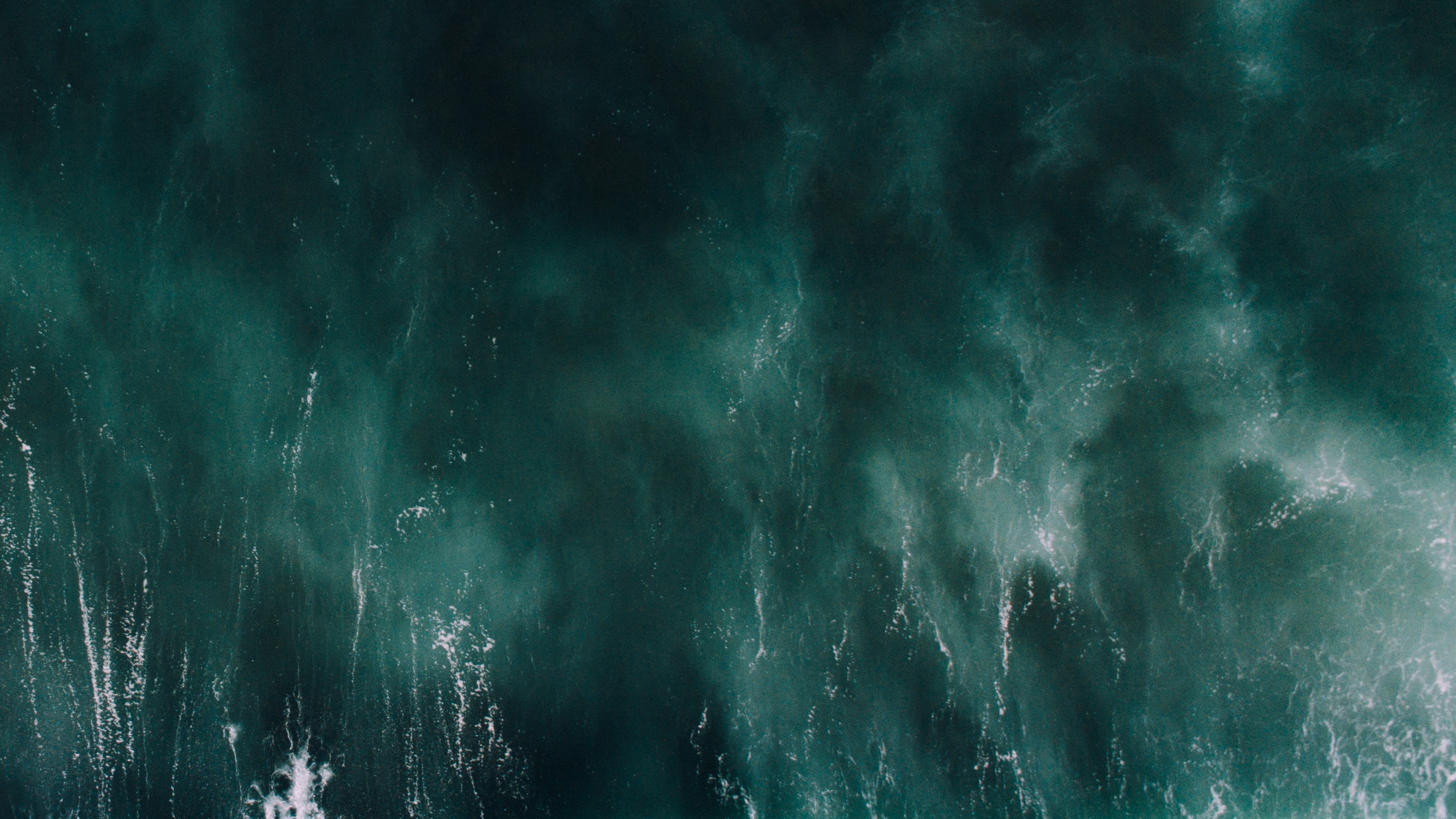 Aerial view of dark green ocean water with white foam HD Wallpaper
