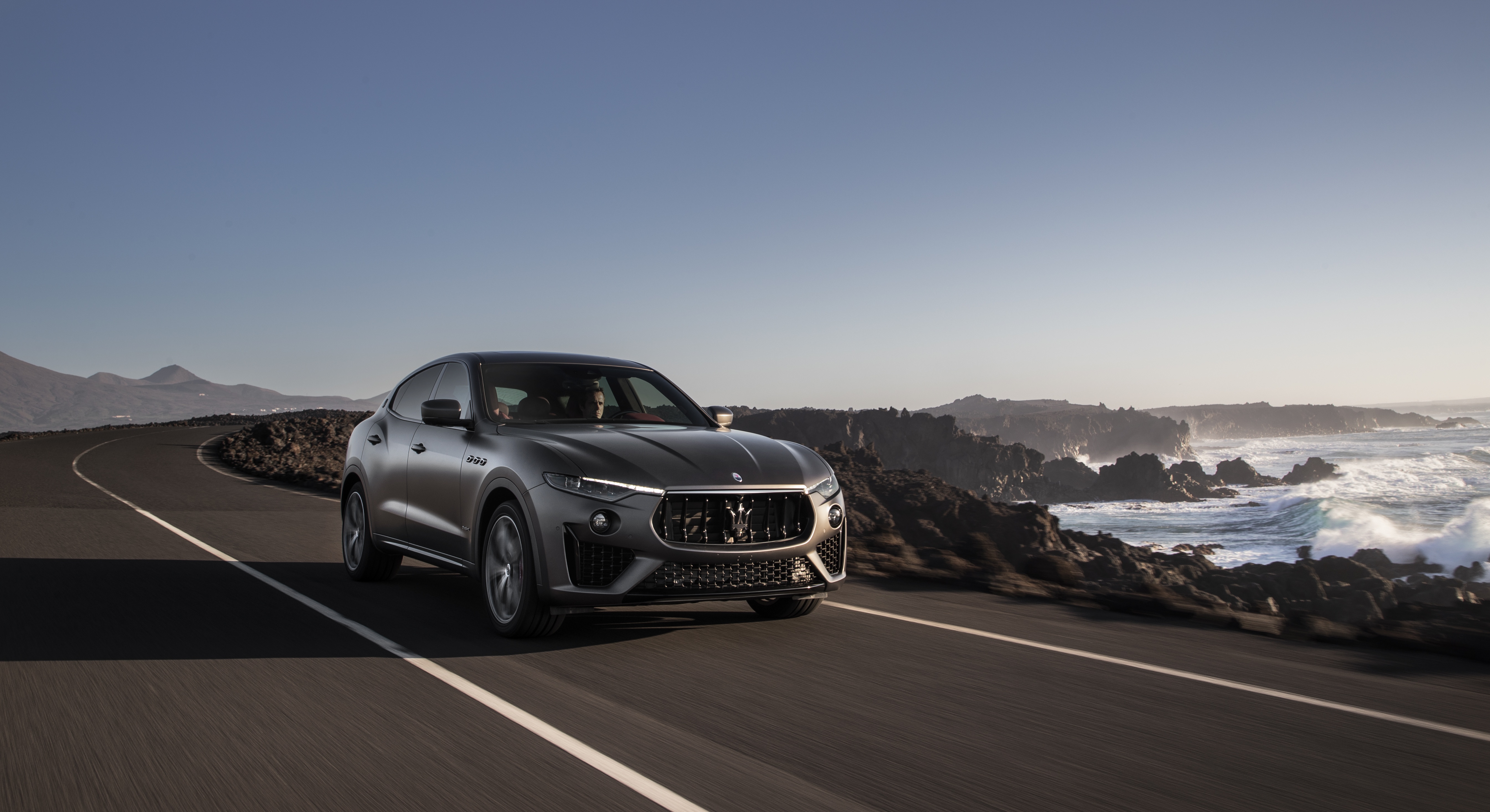 Maserati Levante SUV driving on coastal road HD Wallpaper