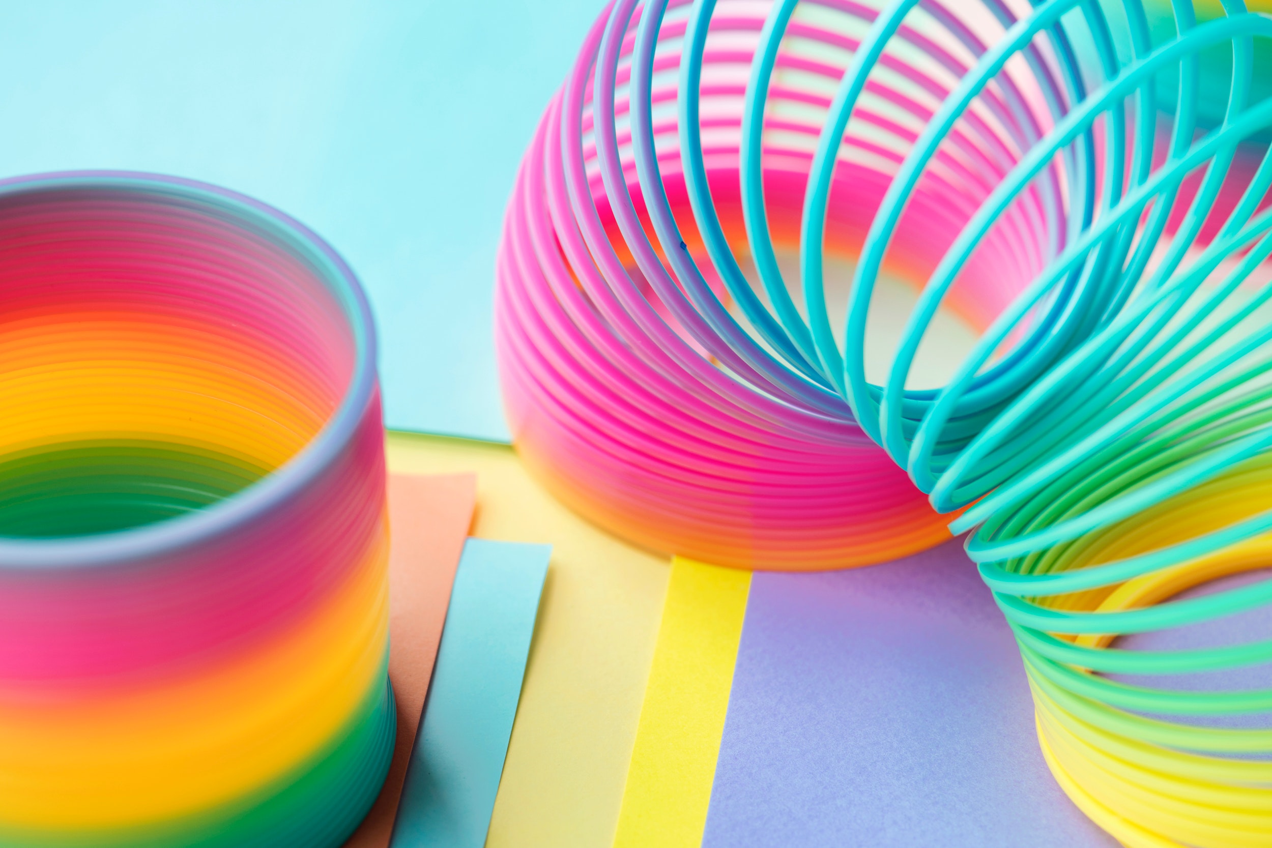 Colorful Slinky Toys on Pastel Paper HD Wallpaper