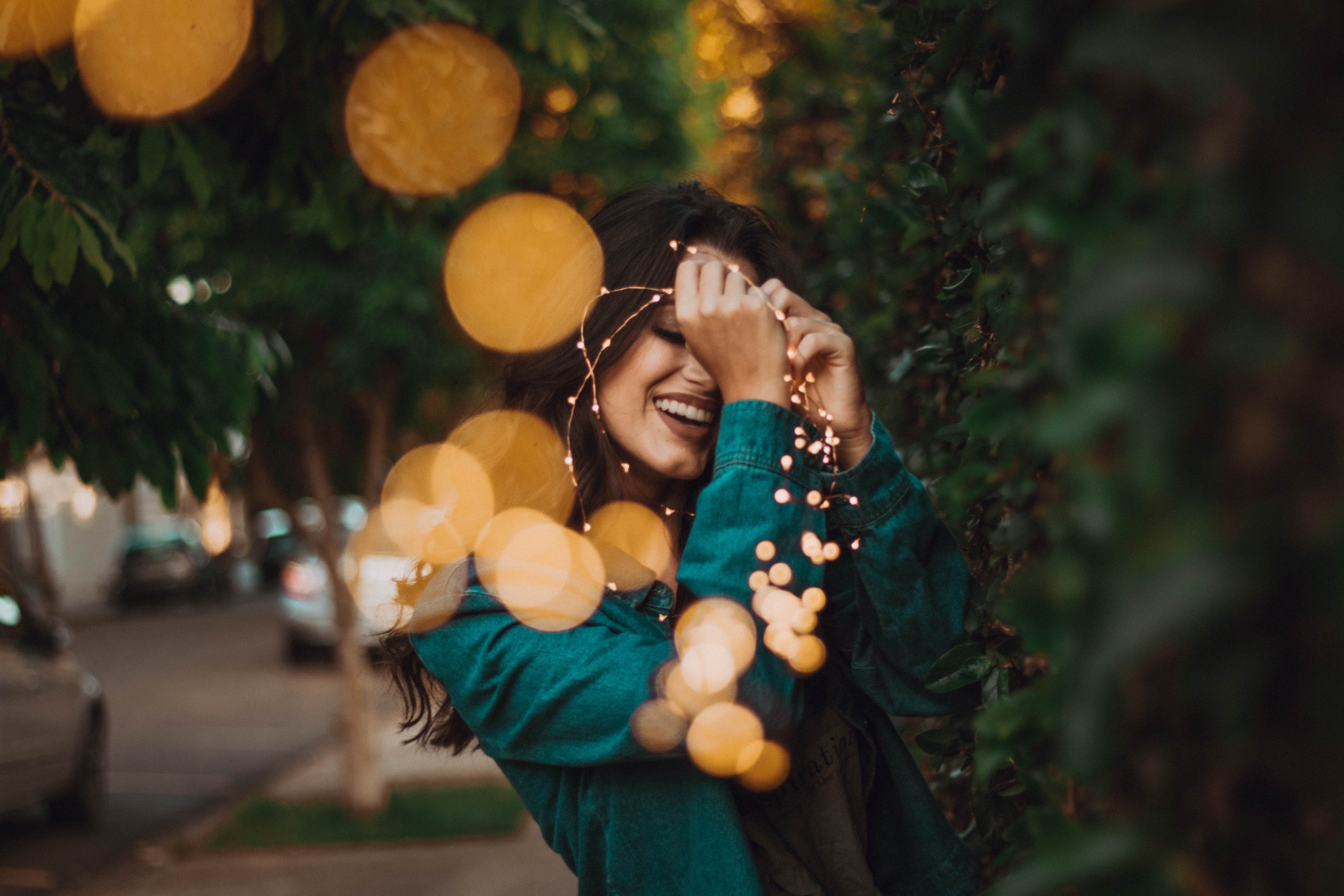 Woman smiling with fairy lights HD Wallpaper
