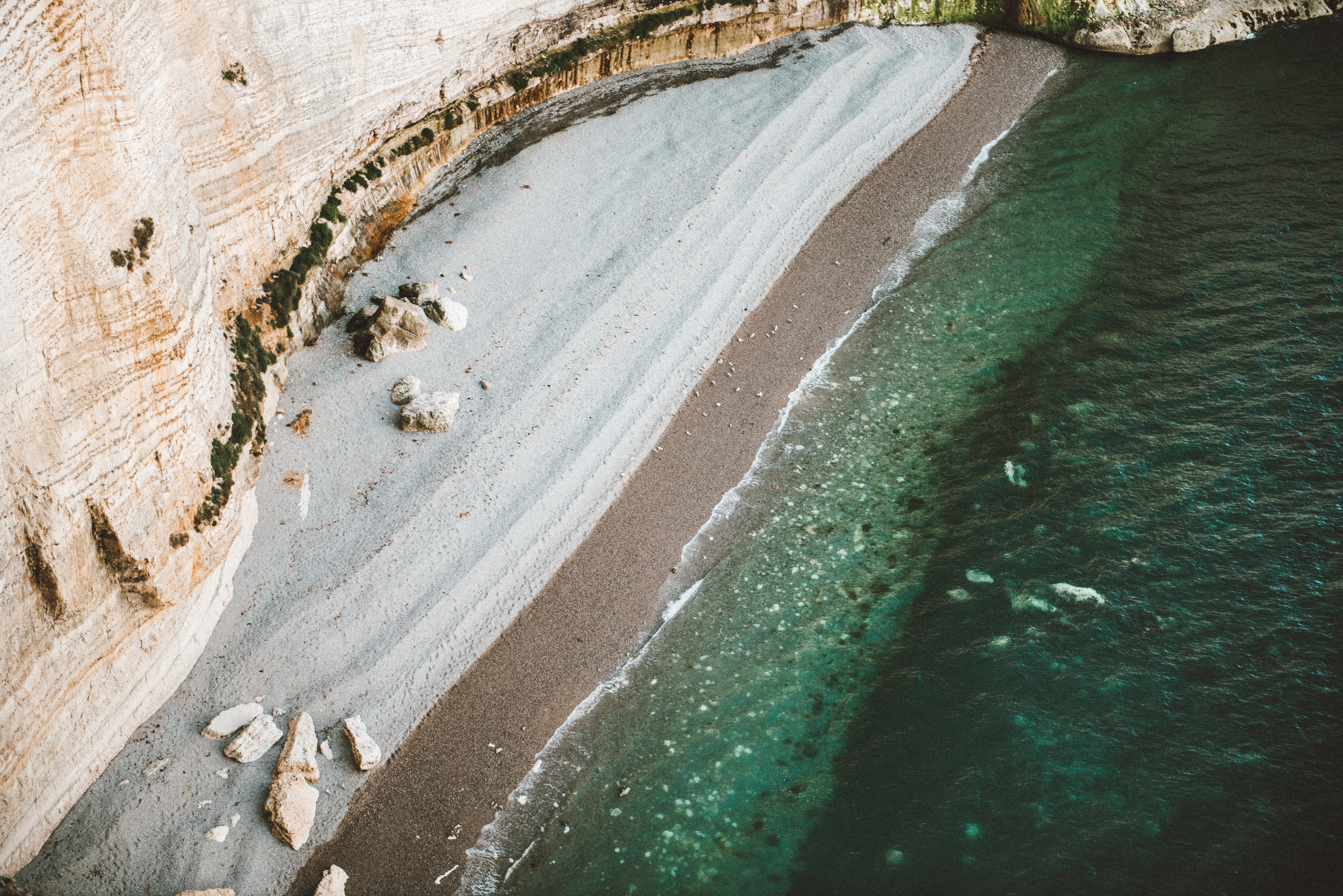 Aerial view of a rocky beach and turquoise ocean HD Wallpaper