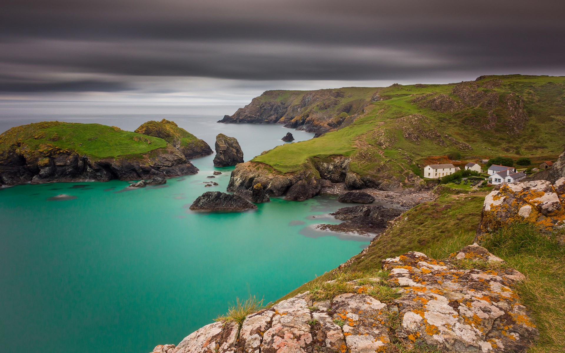 Coastal village with turquoise water and rocky cliffs HD Wallpaper