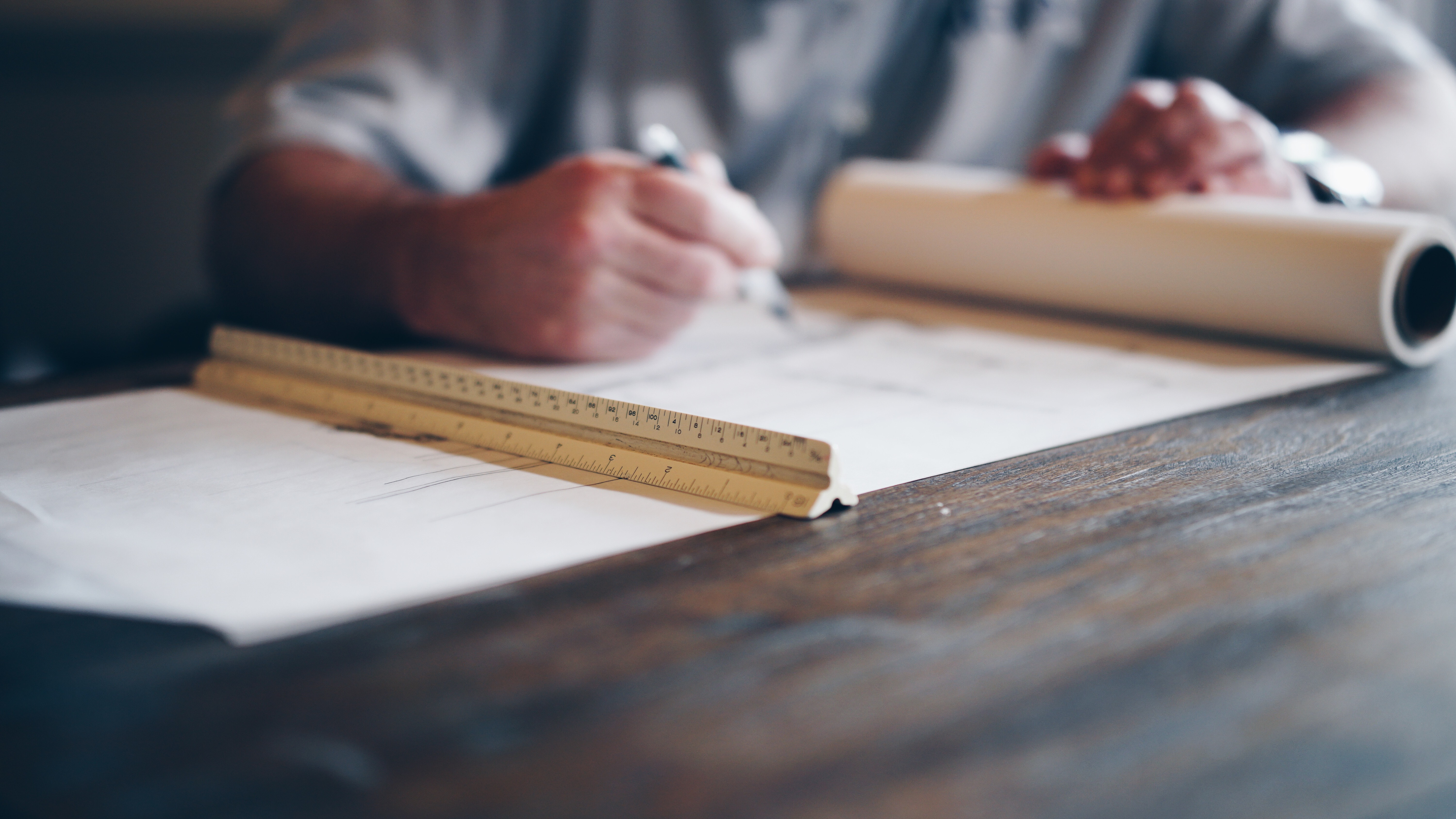 Architect working on blueprints with ruler and pen HD Wallpaper