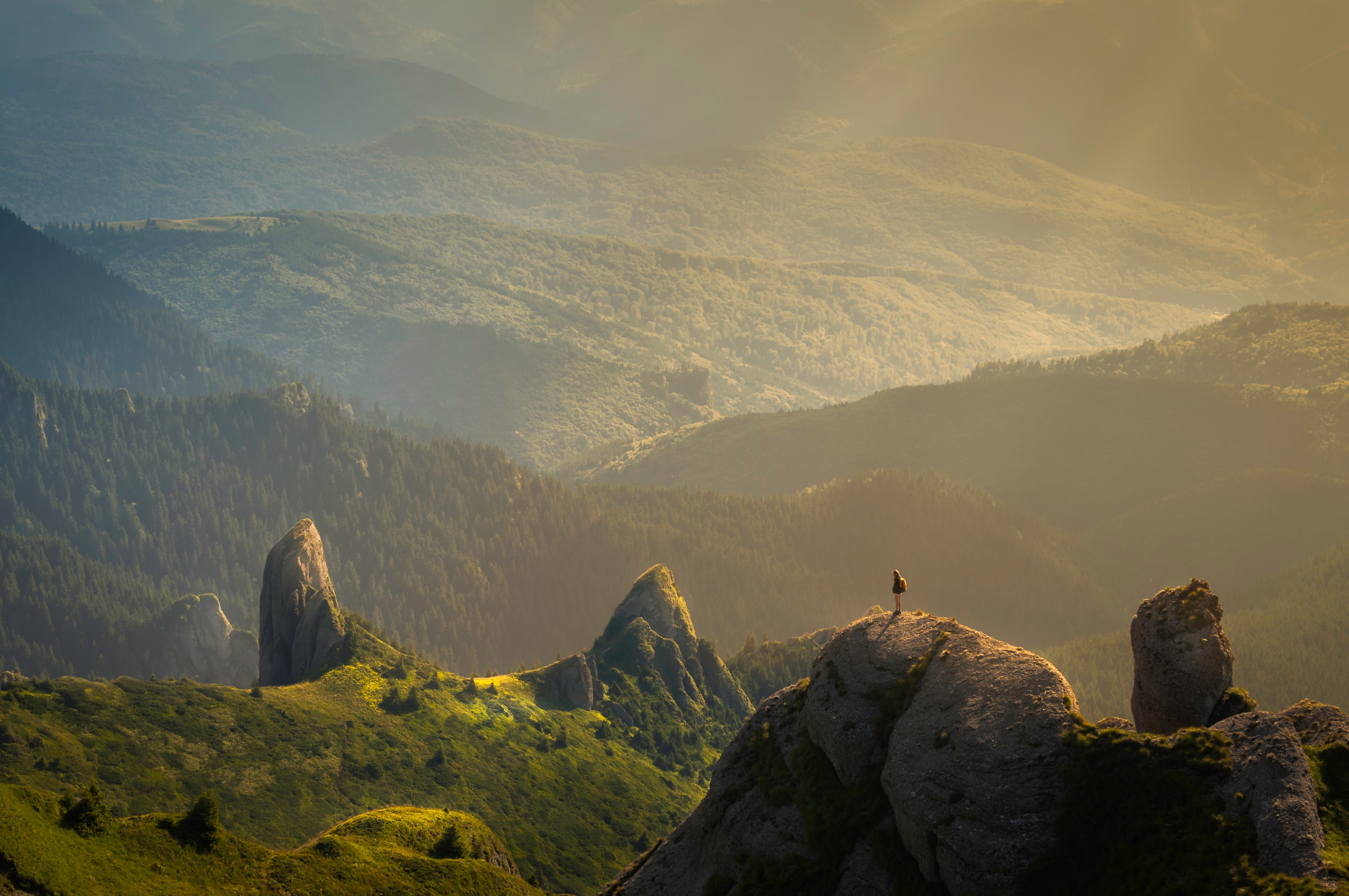 Hiker on a rocky mountain ridge at sunrise HD Wallpaper