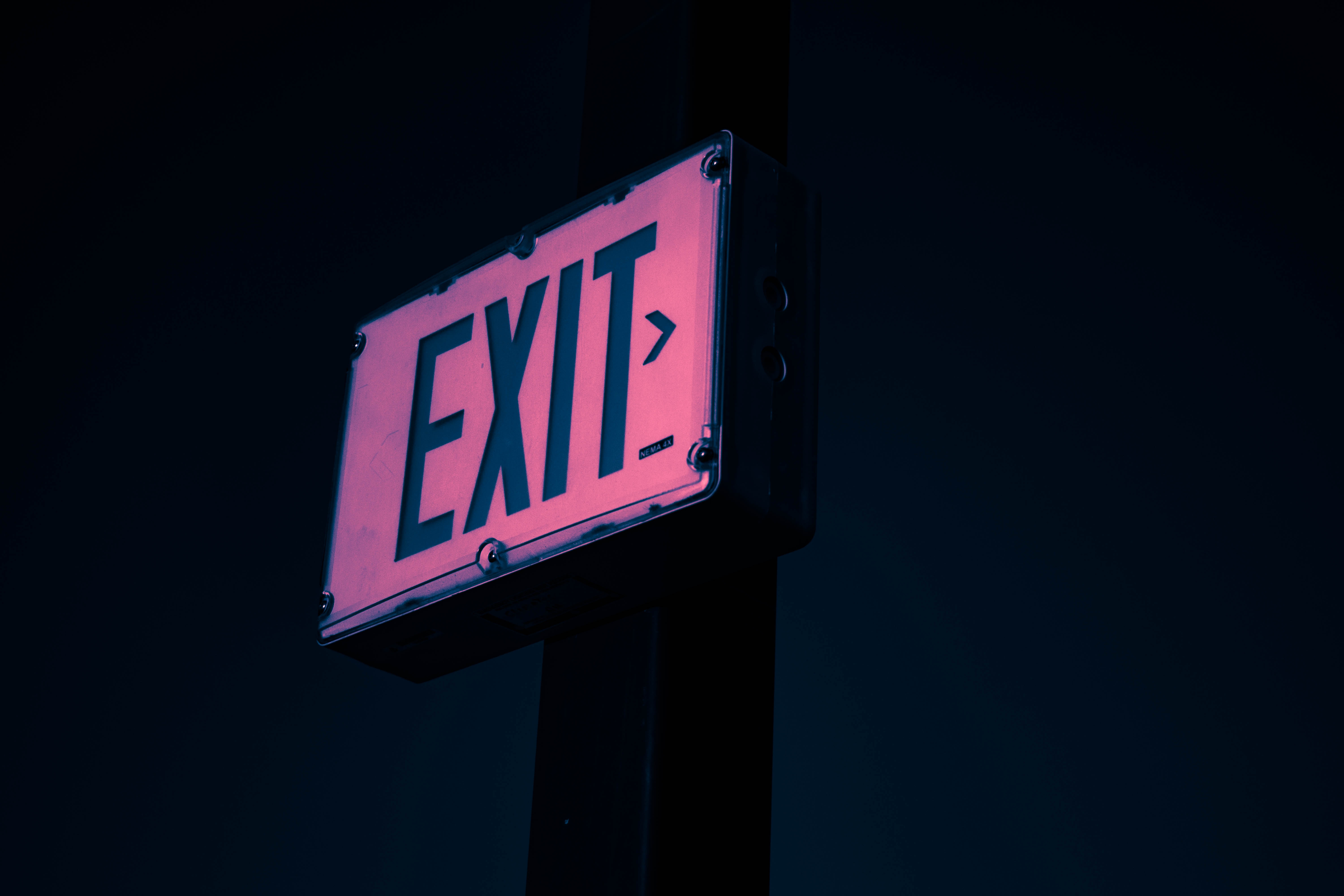 Exit sign illuminated in pink and blue light HD Wallpaper