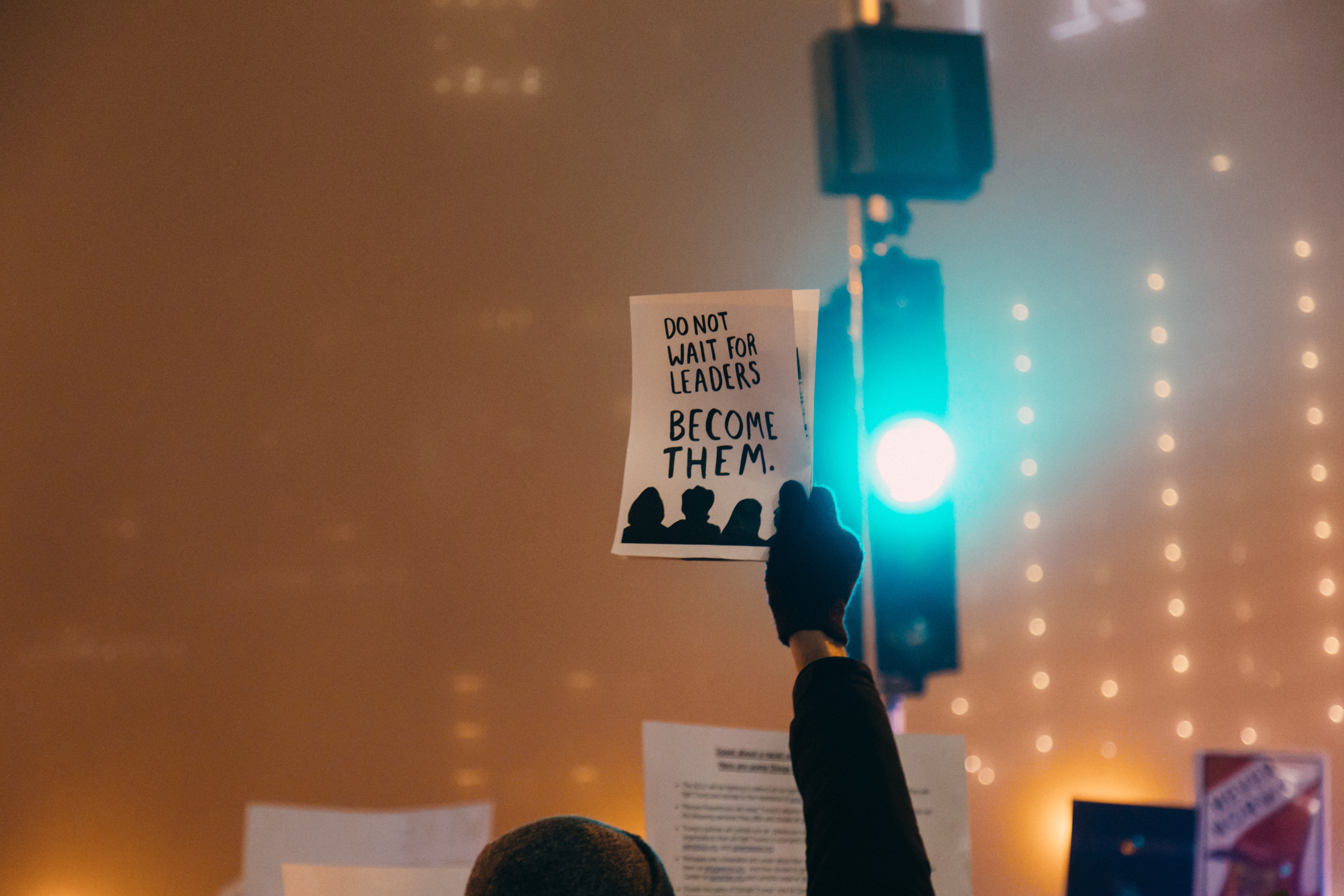 Person holds poster with message 'DO NOT WAIT FOR LEADERS BECOME THEM.' HD Wallpaper