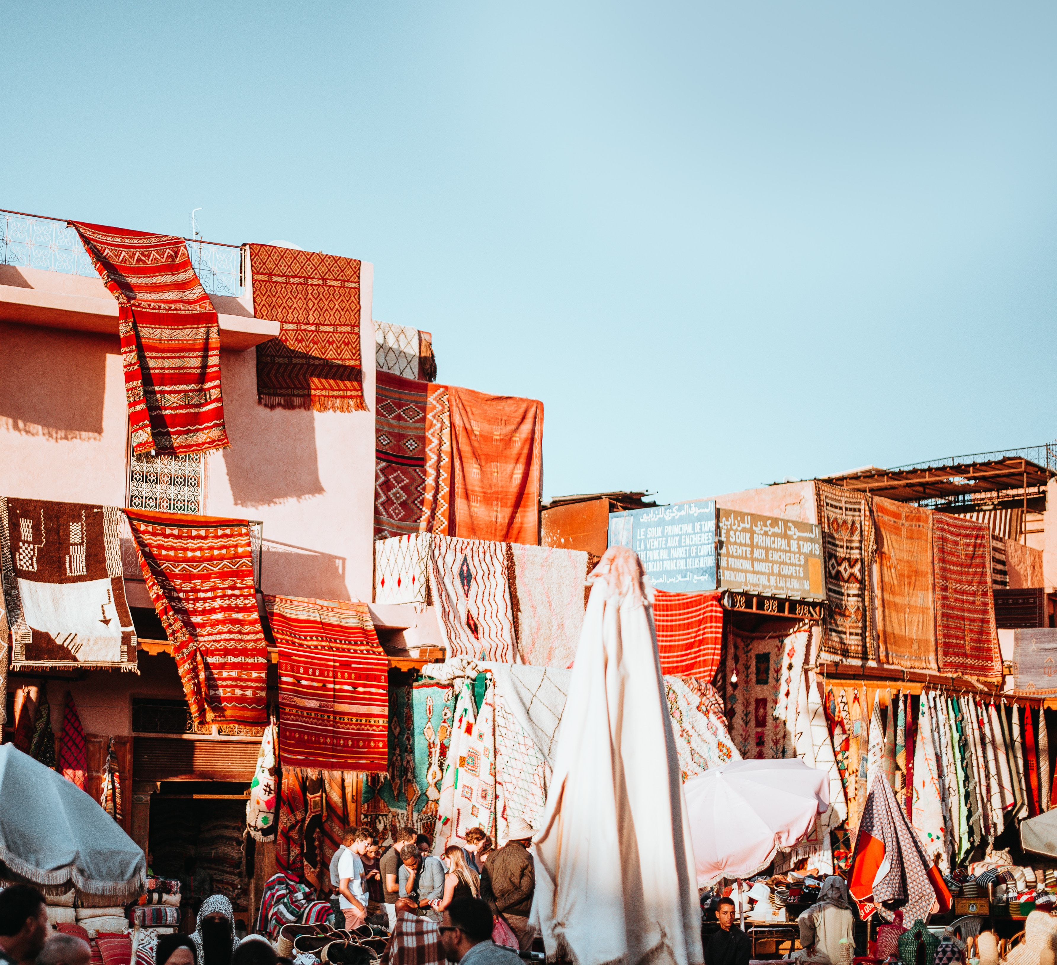 Marketplace with colorful textiles and people HD Wallpaper