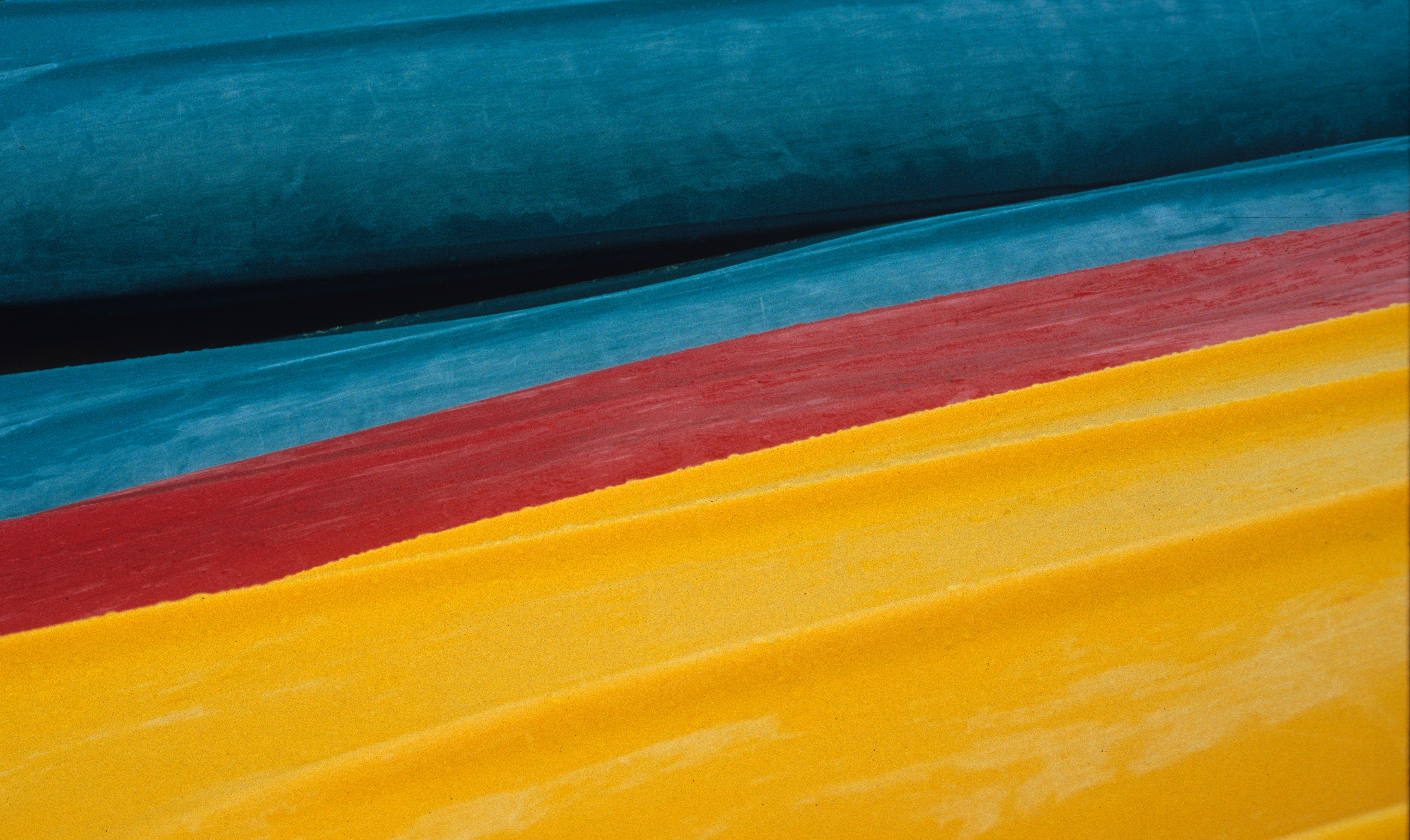 Three colorful kayaks in blue, red, and yellow HD Wallpaper