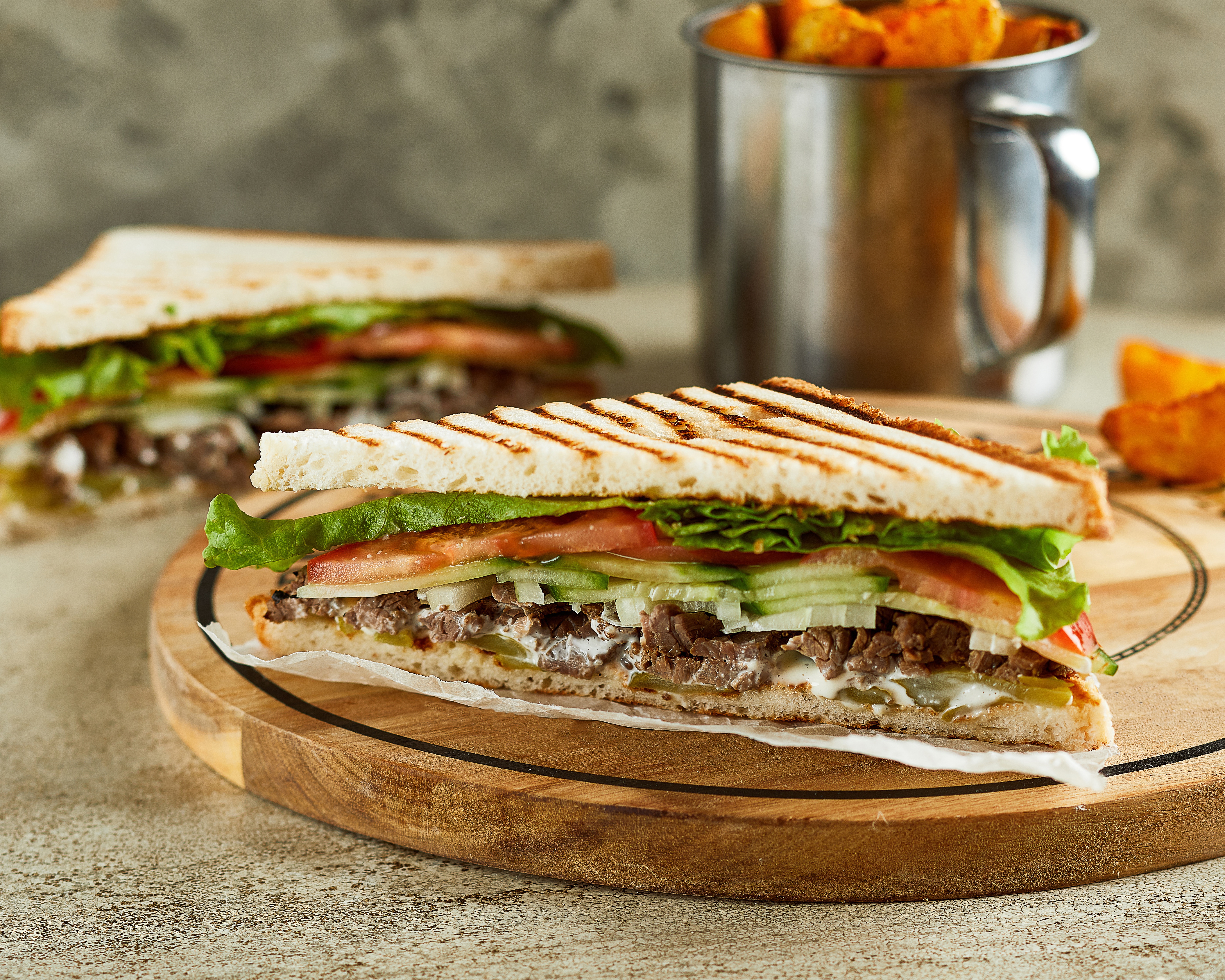 Grilled sandwich with meat and vegetables, served with potato wedges HD Wallpaper