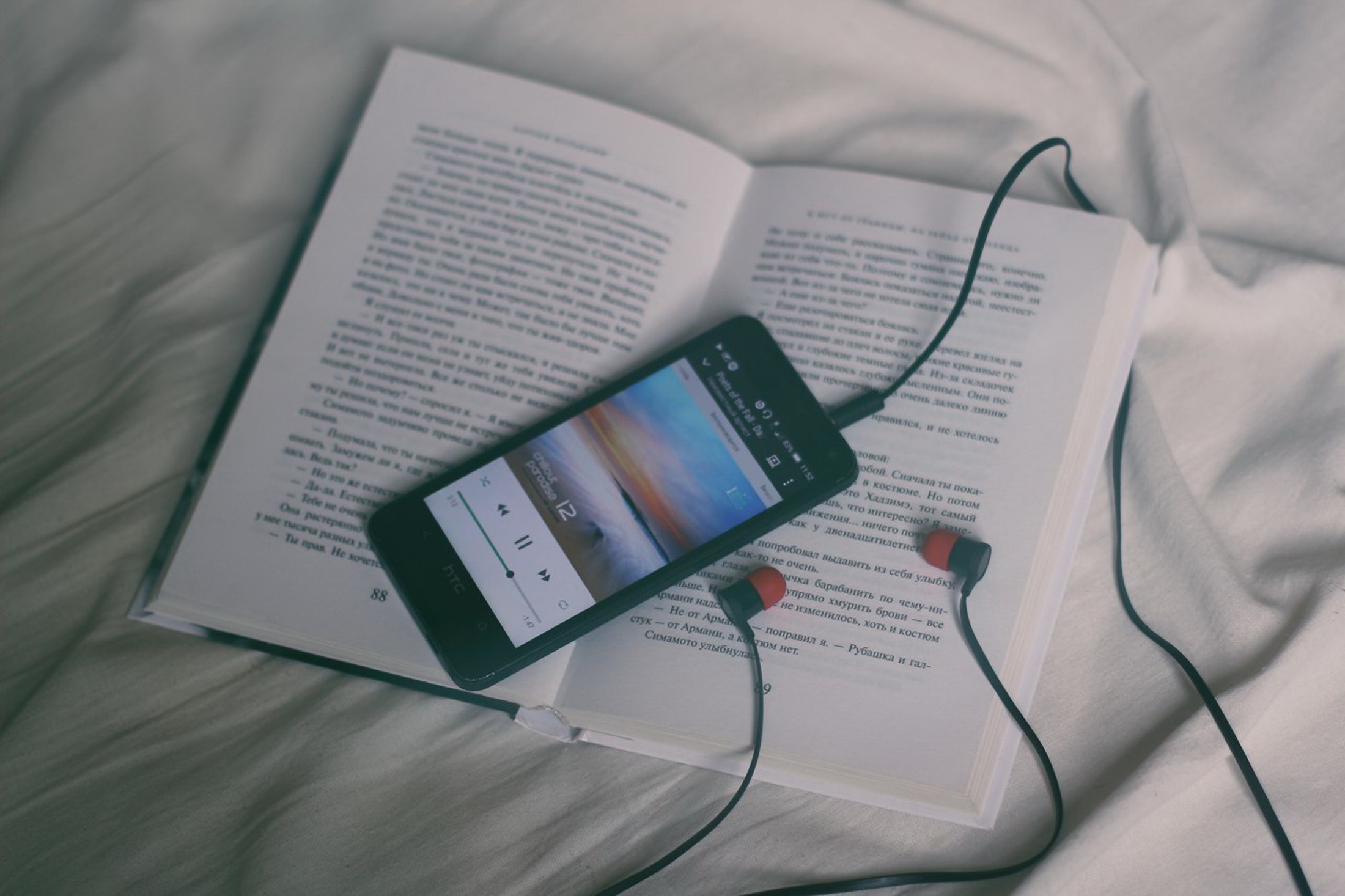 Smartphone with headphones on an open book HD Wallpaper