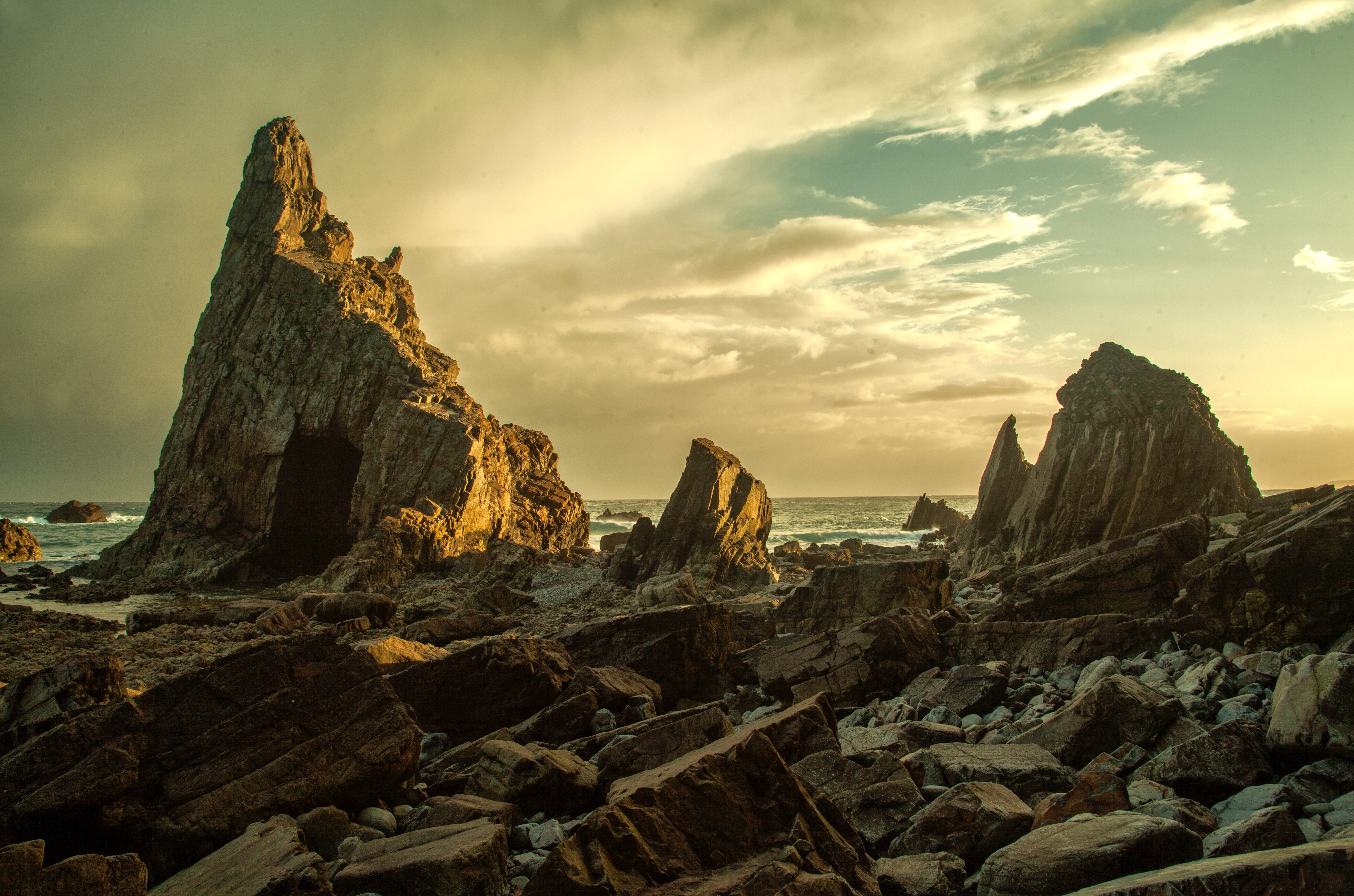 Rocky coastline with a cave and dramatic rock formations HD Wallpaper