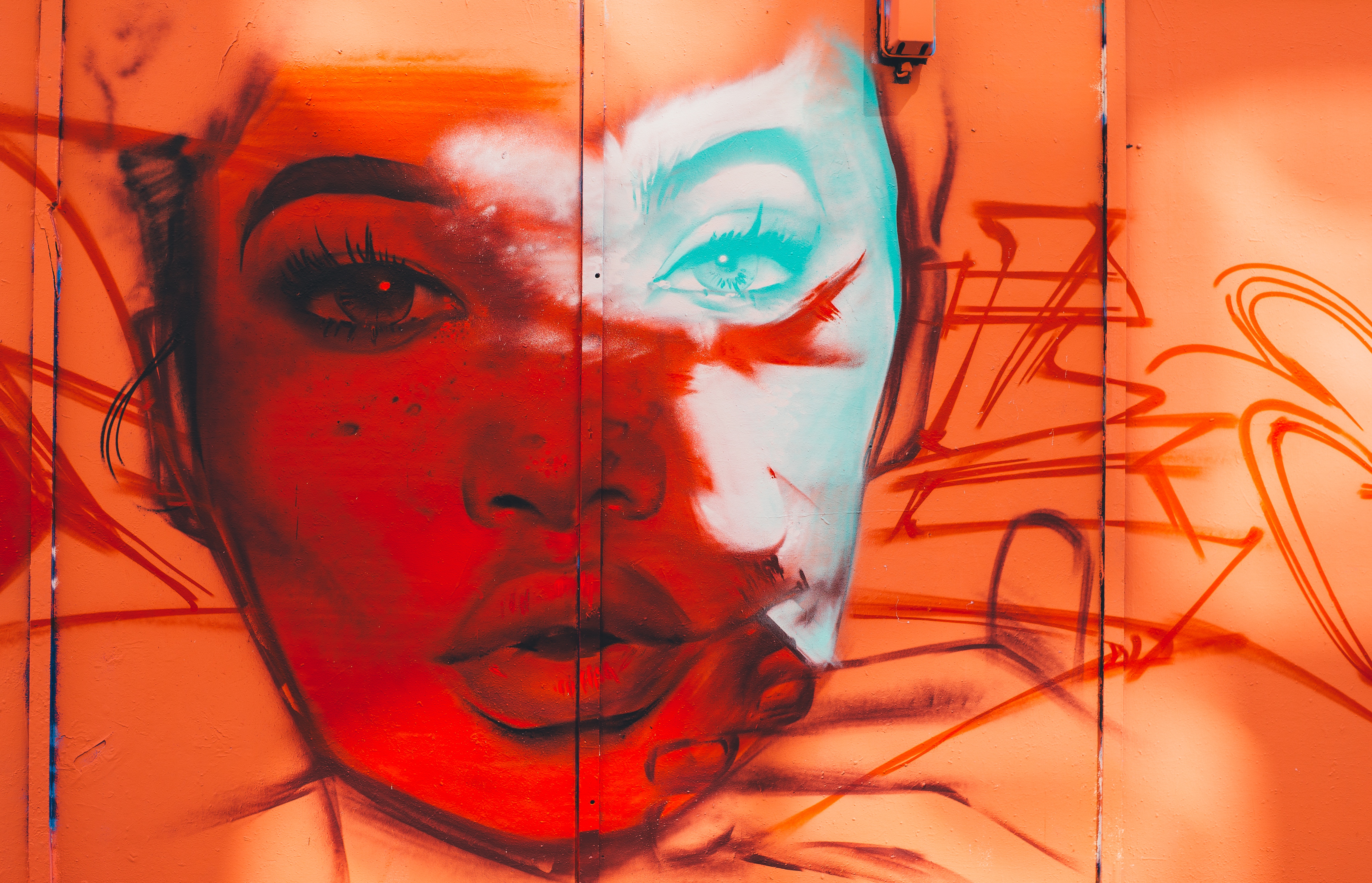 Graffiti art of a woman's face on an orange wall HD Wallpaper